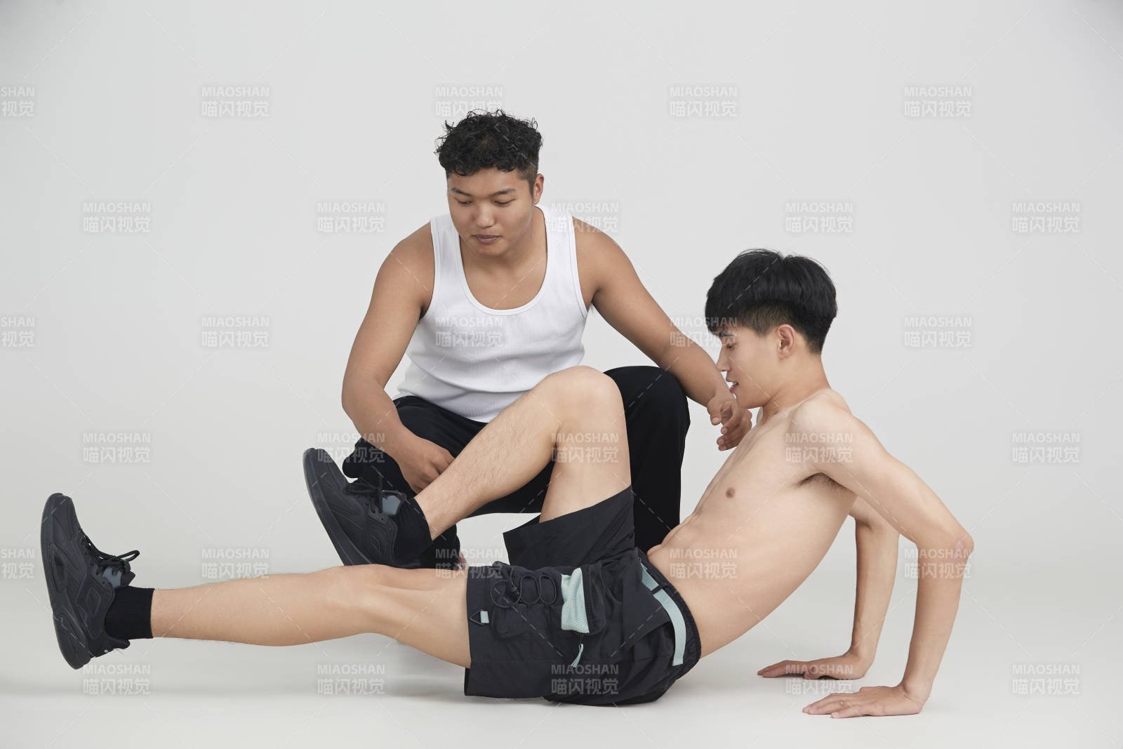 年輕男子在教練的指導下健身