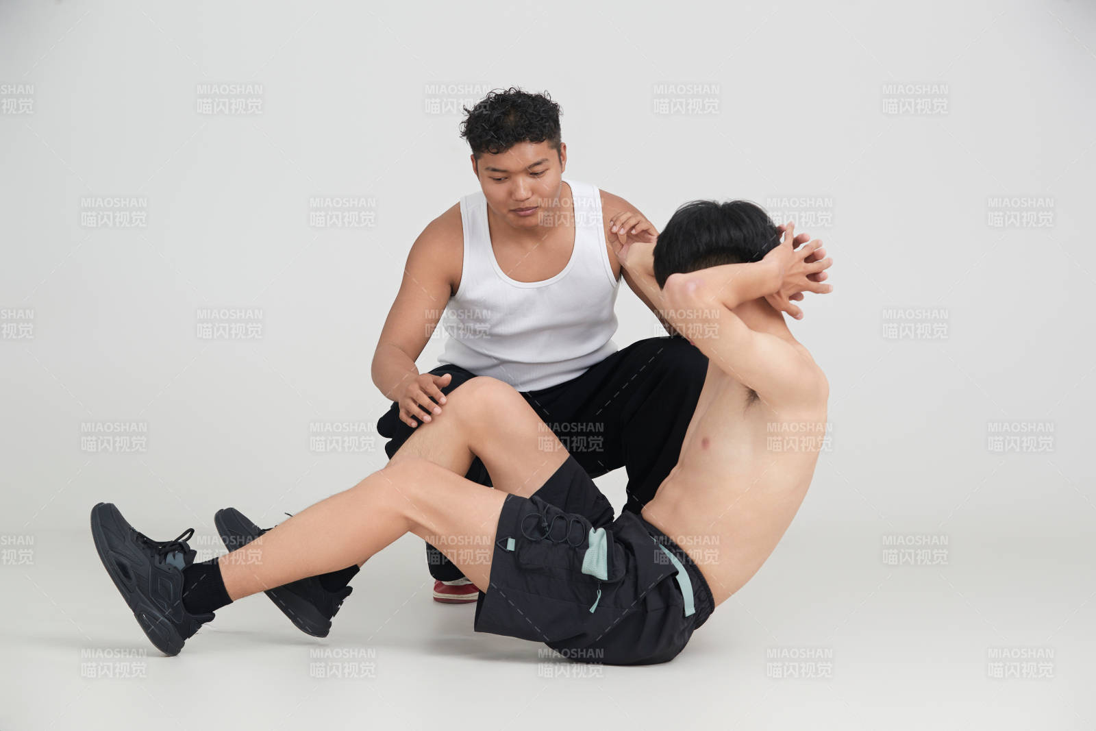 年輕男子在教練的指導(dǎo)下健身