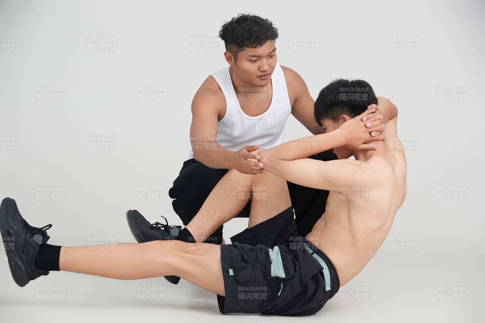 年輕男子在教練的指導(dǎo)下健身