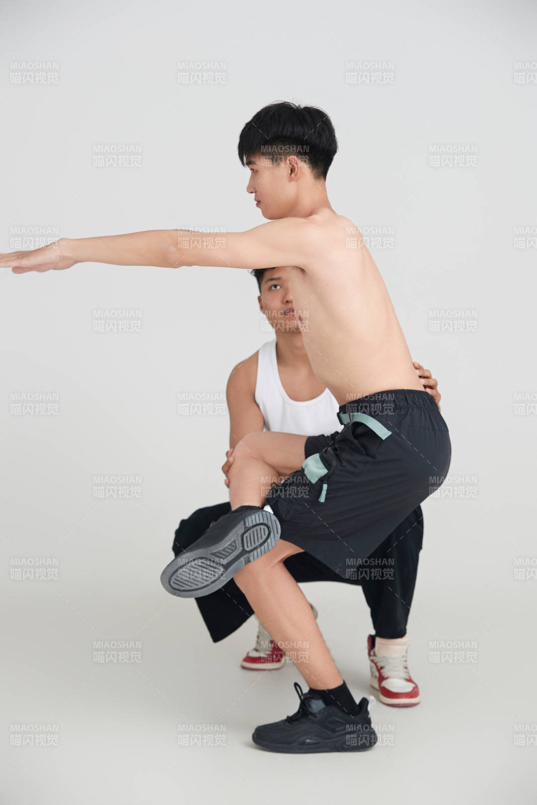 年輕男子在教練的指導下健身