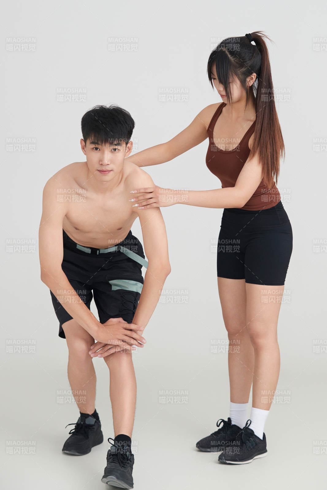 年輕男子在美女教練的指導下健身