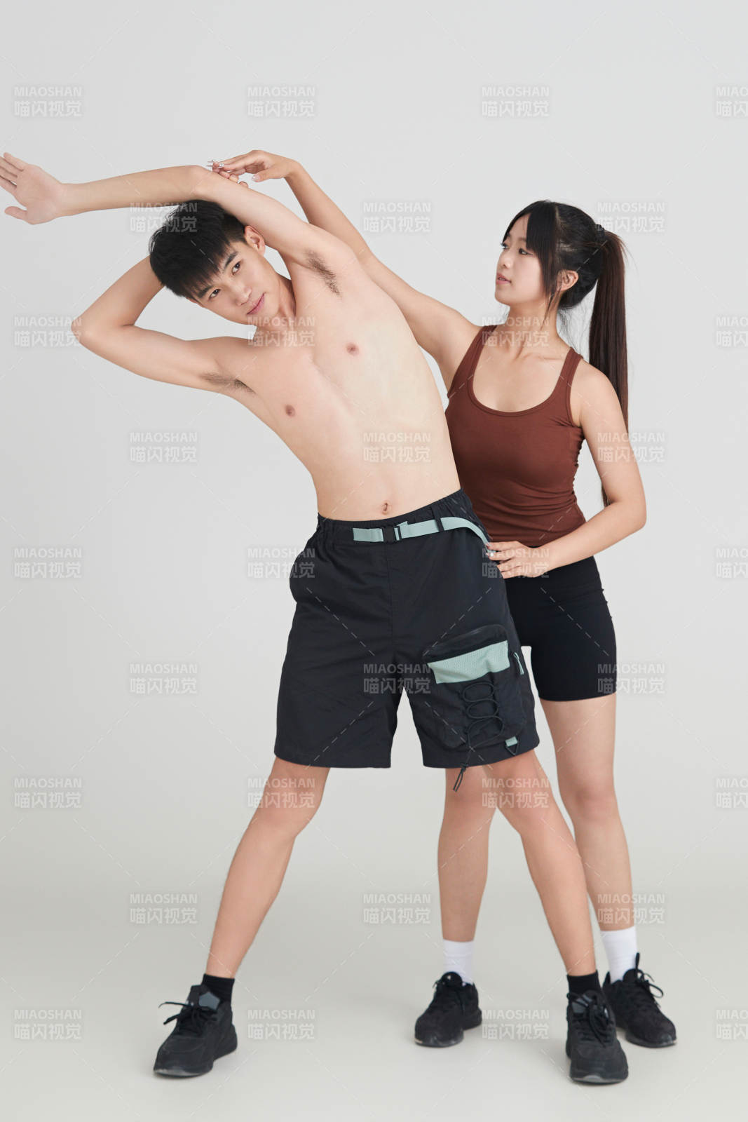 年輕男子在美女教練的指導下健身