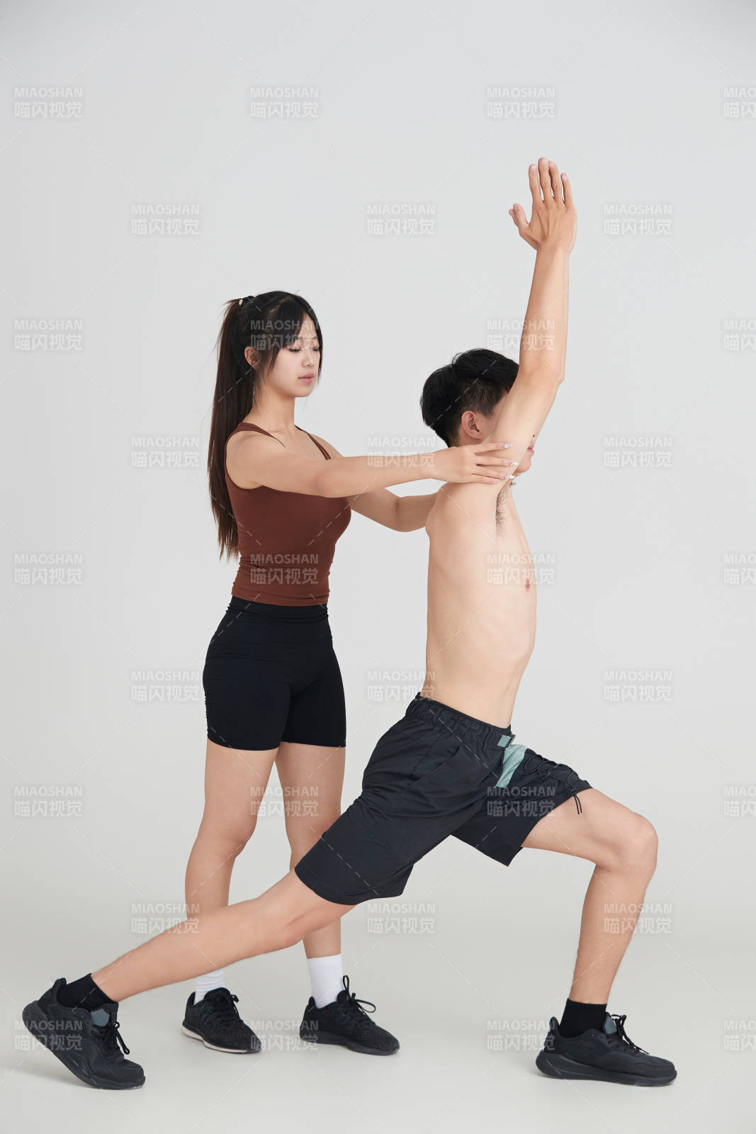 年轻男子在美女教练的指导下健身