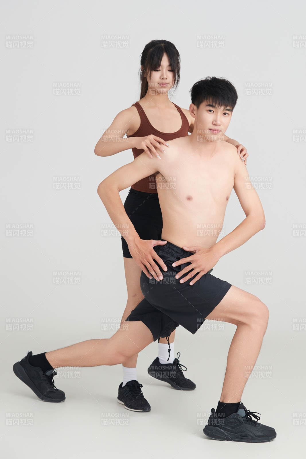 年輕男子在美女教練的指導下健身