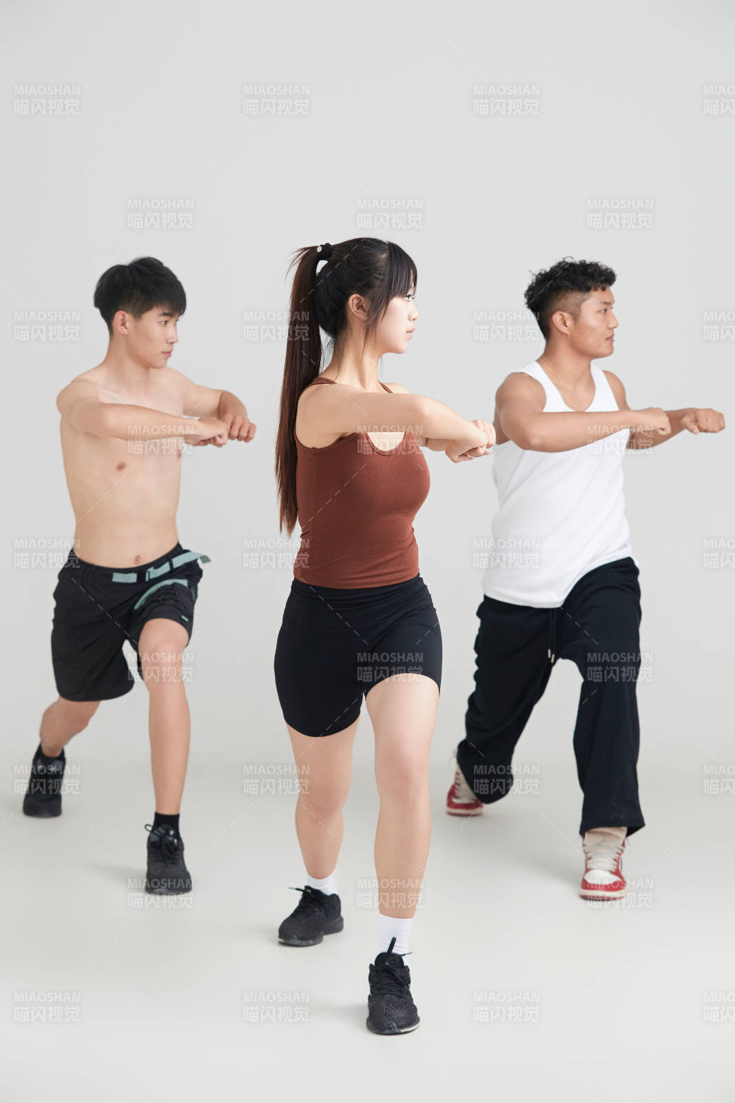 兩名年輕男子在美女教練的帶領(lǐng)下做健身操