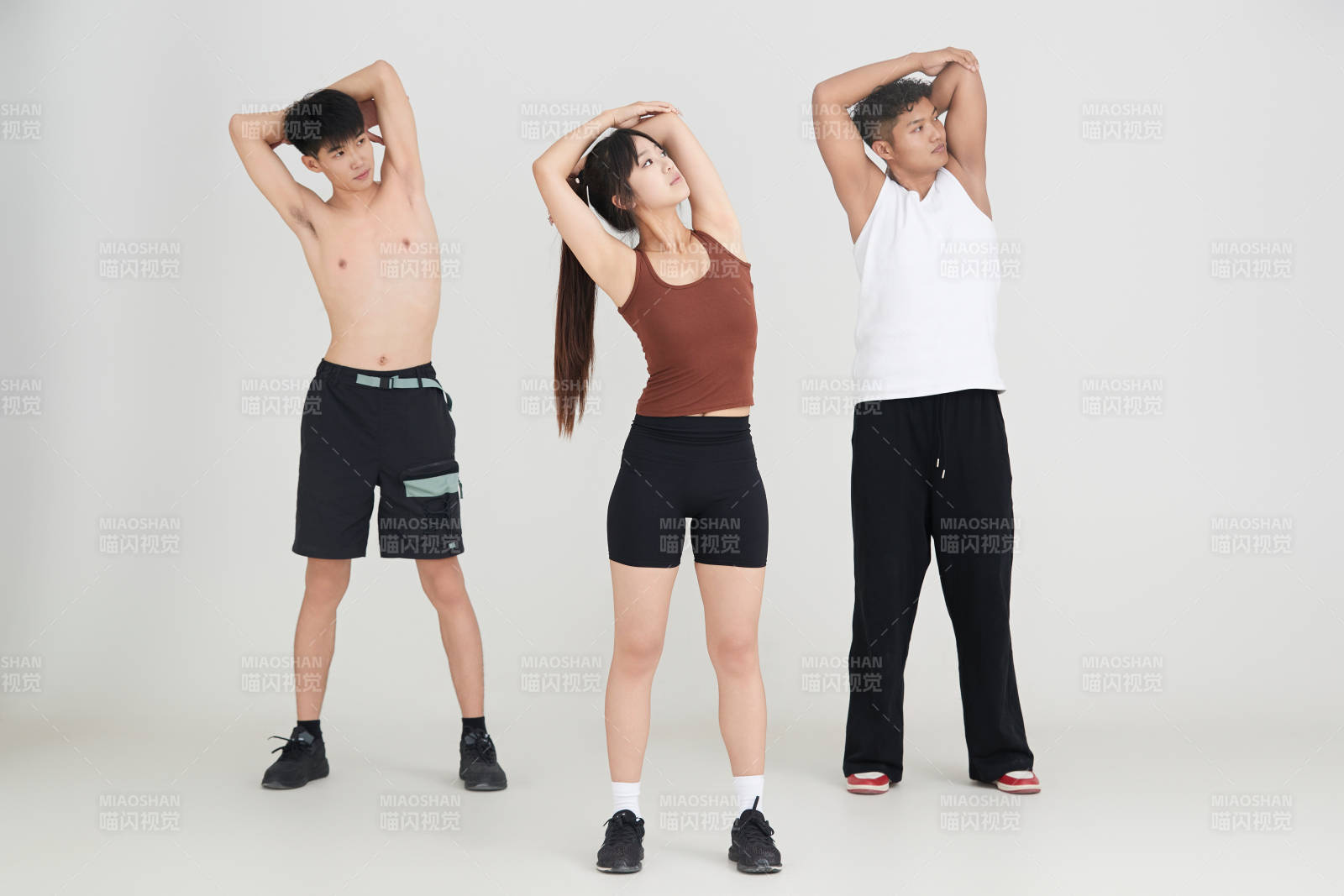 兩名年輕男子在美女教練的帶領(lǐng)下做健身操