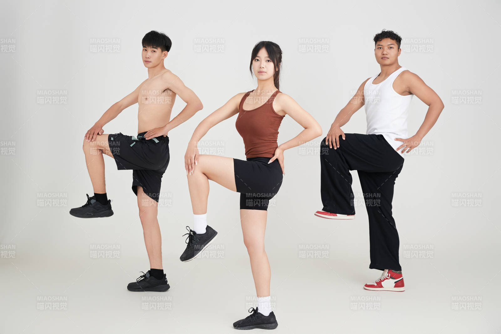 兩名年輕男子在美女教練的帶領(lǐng)下做健身操