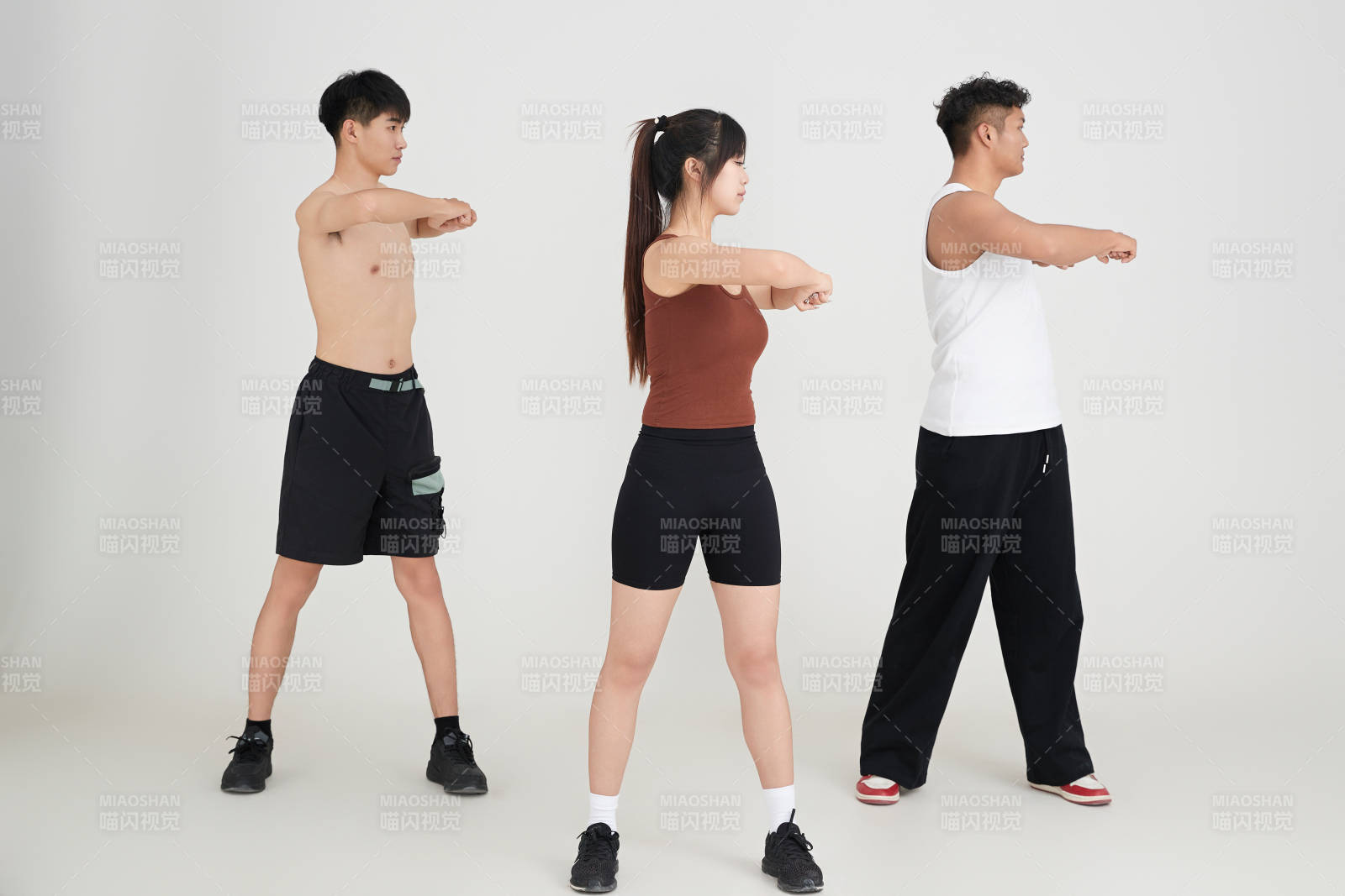 兩名年輕男子在美女教練的帶領(lǐng)下做健身操