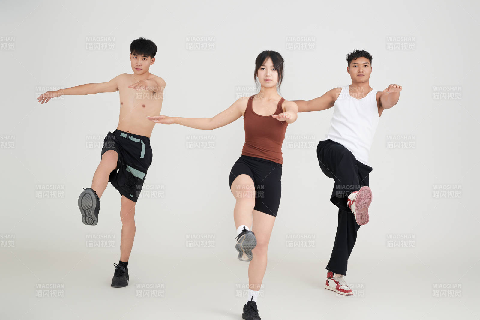 兩名年輕男子在美女教練的帶領(lǐng)下做健身操