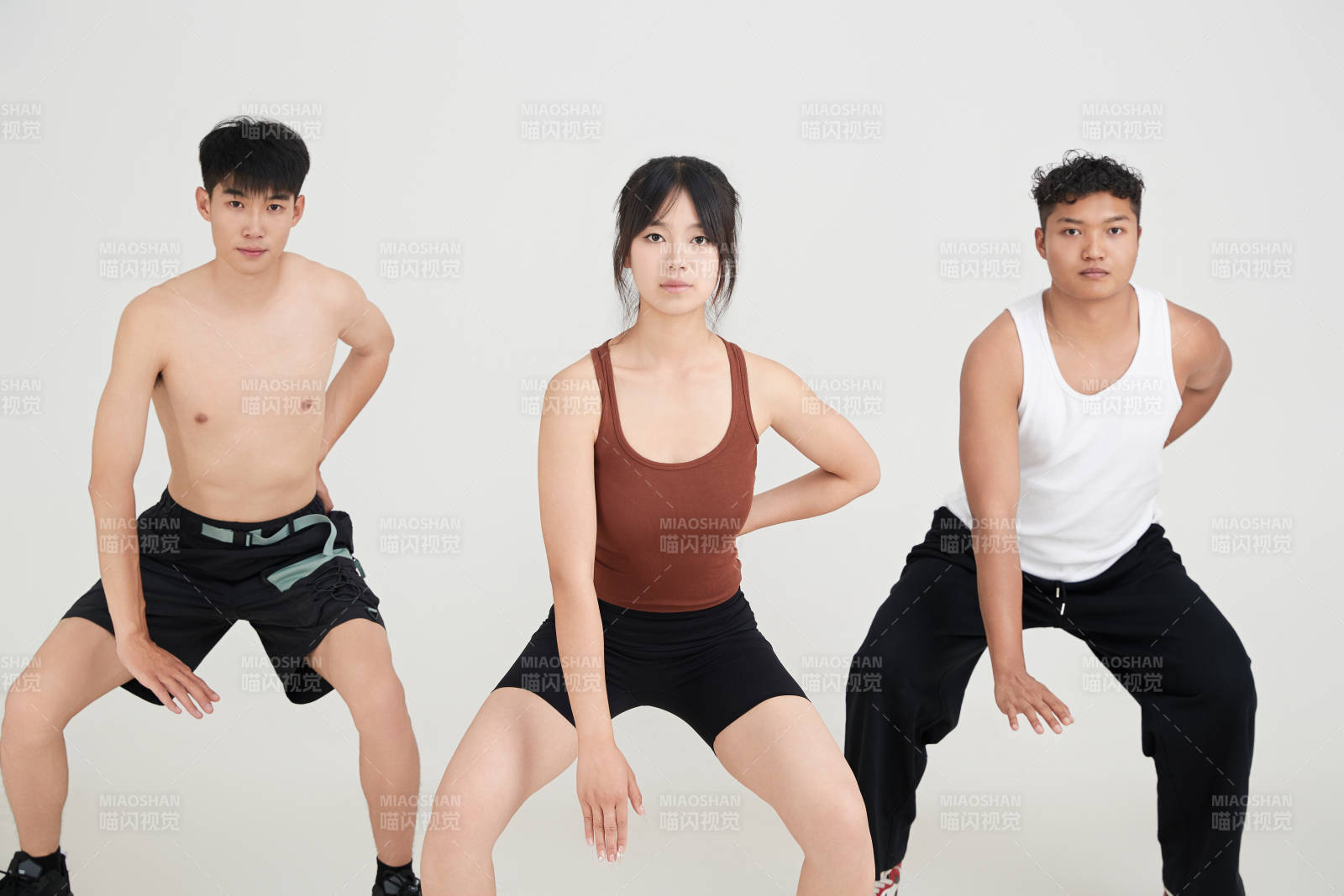 兩名年輕男子在美女教練的帶領(lǐng)下做健身操