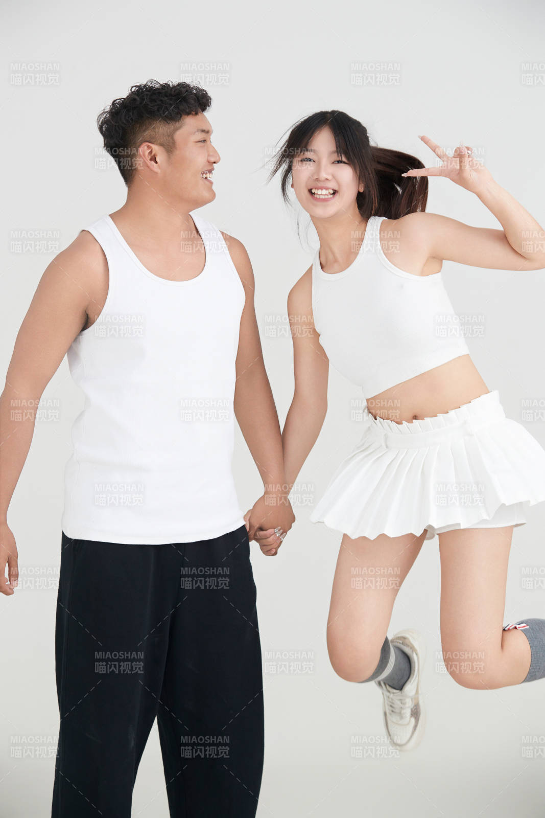 白色背景下嬉戲歡樂(lè)的亞洲情侶