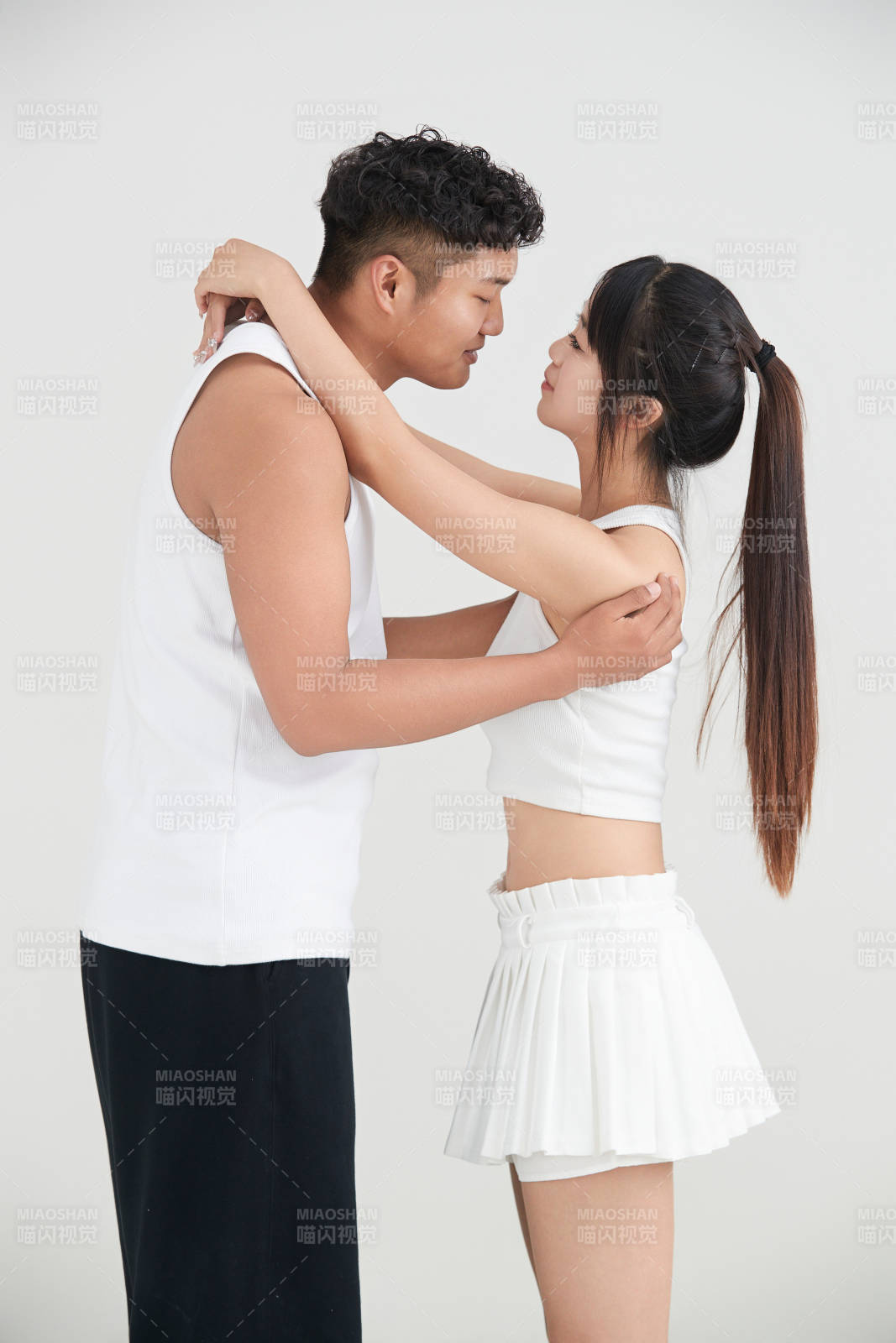 白色背景下嬉戲歡樂的亞洲情侶