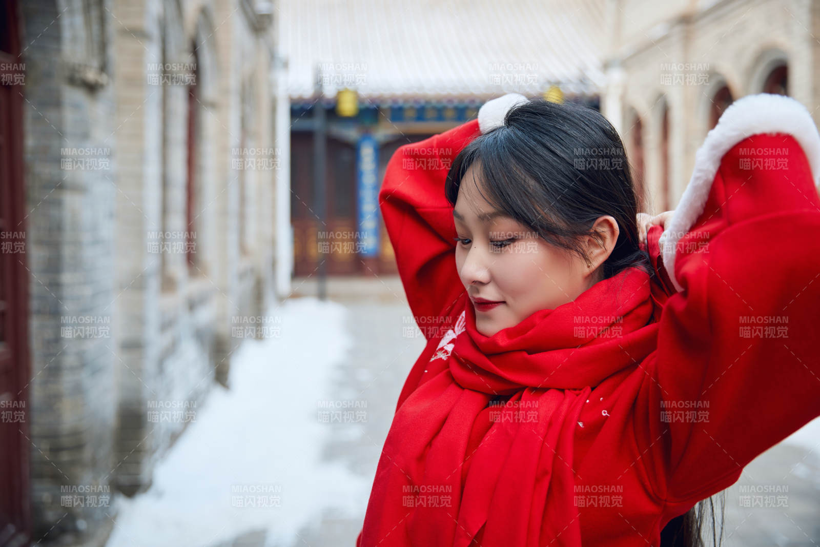 雪后在老城古巷穿著喜慶服飾的亞洲少女