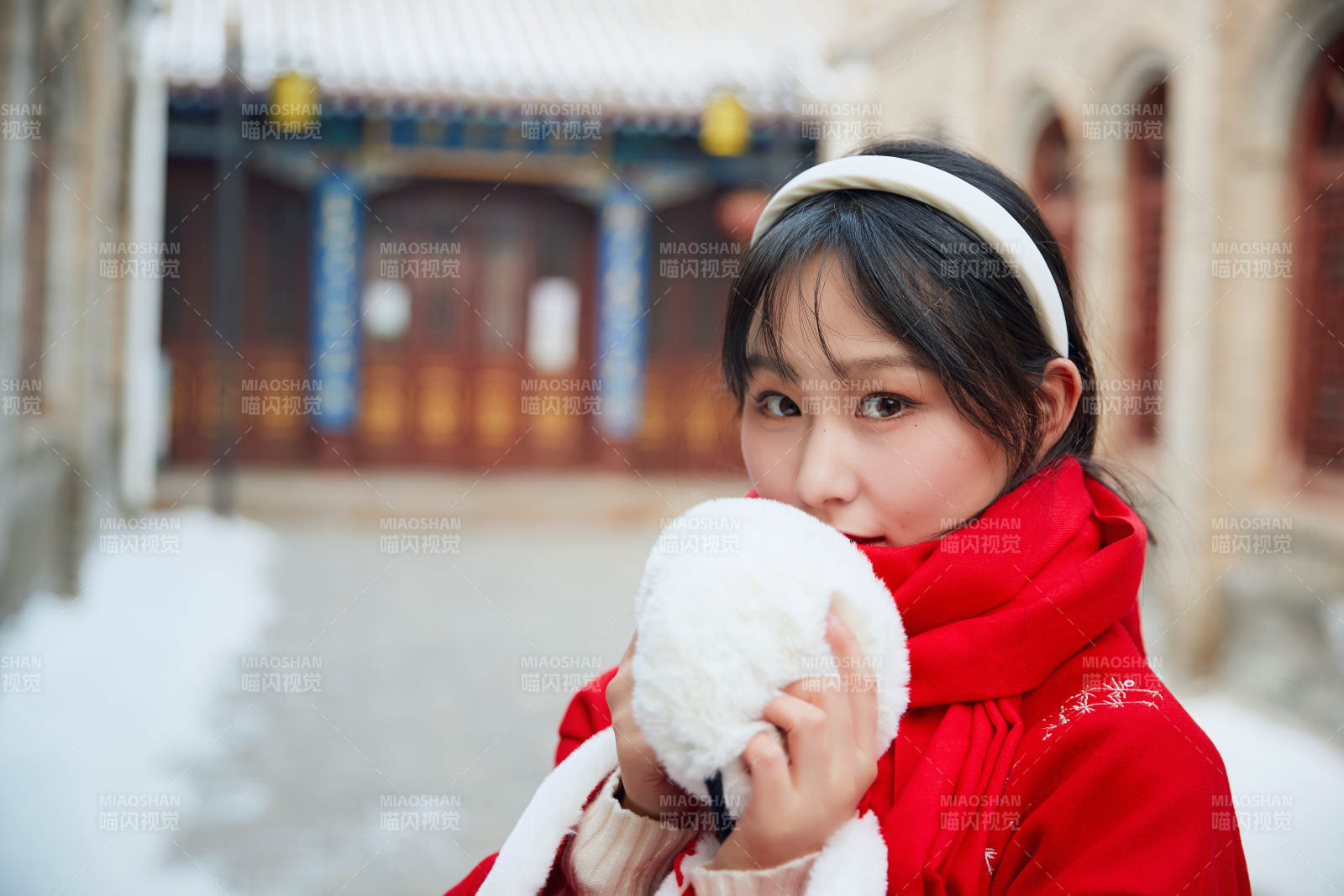 雪后在老城古巷穿著喜慶服飾的亞洲少女