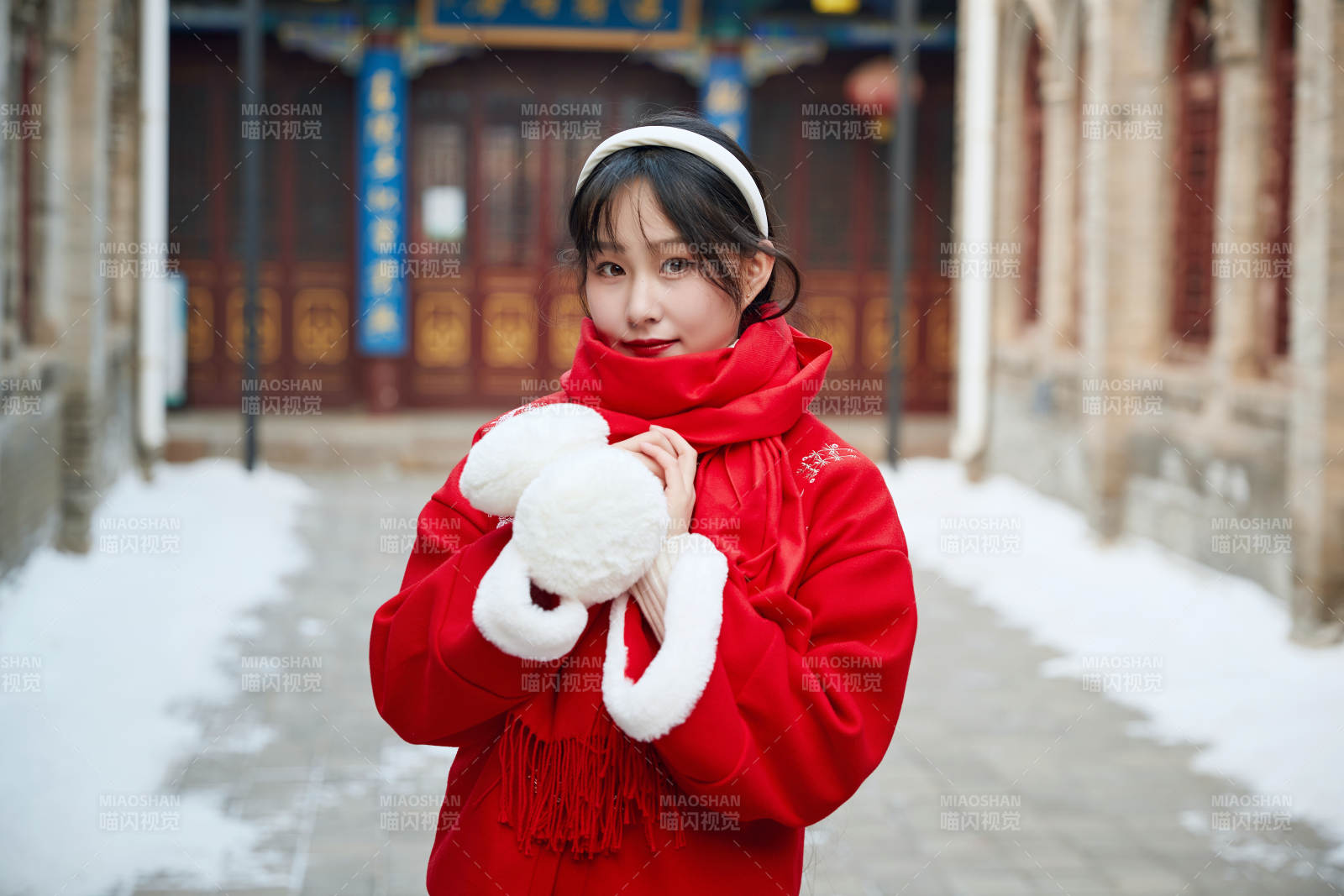 雪后在老城古巷穿著喜慶服飾的亞洲少女