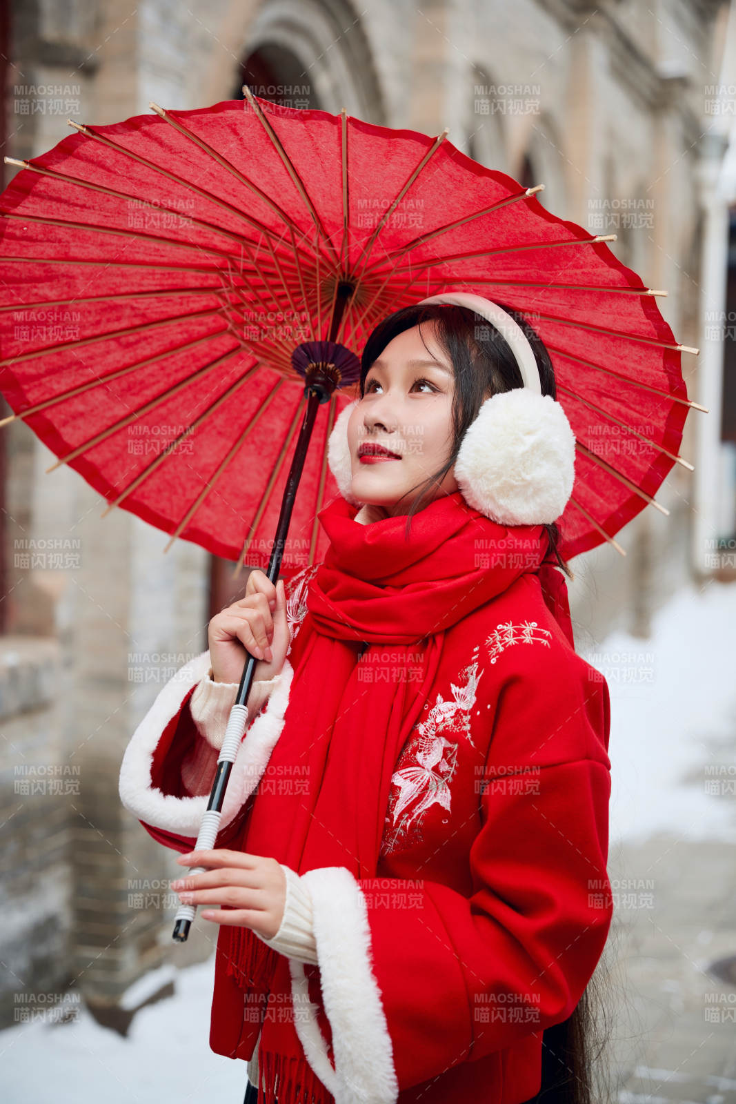 雪后在老城古巷穿著喜慶服飾的亞洲少女