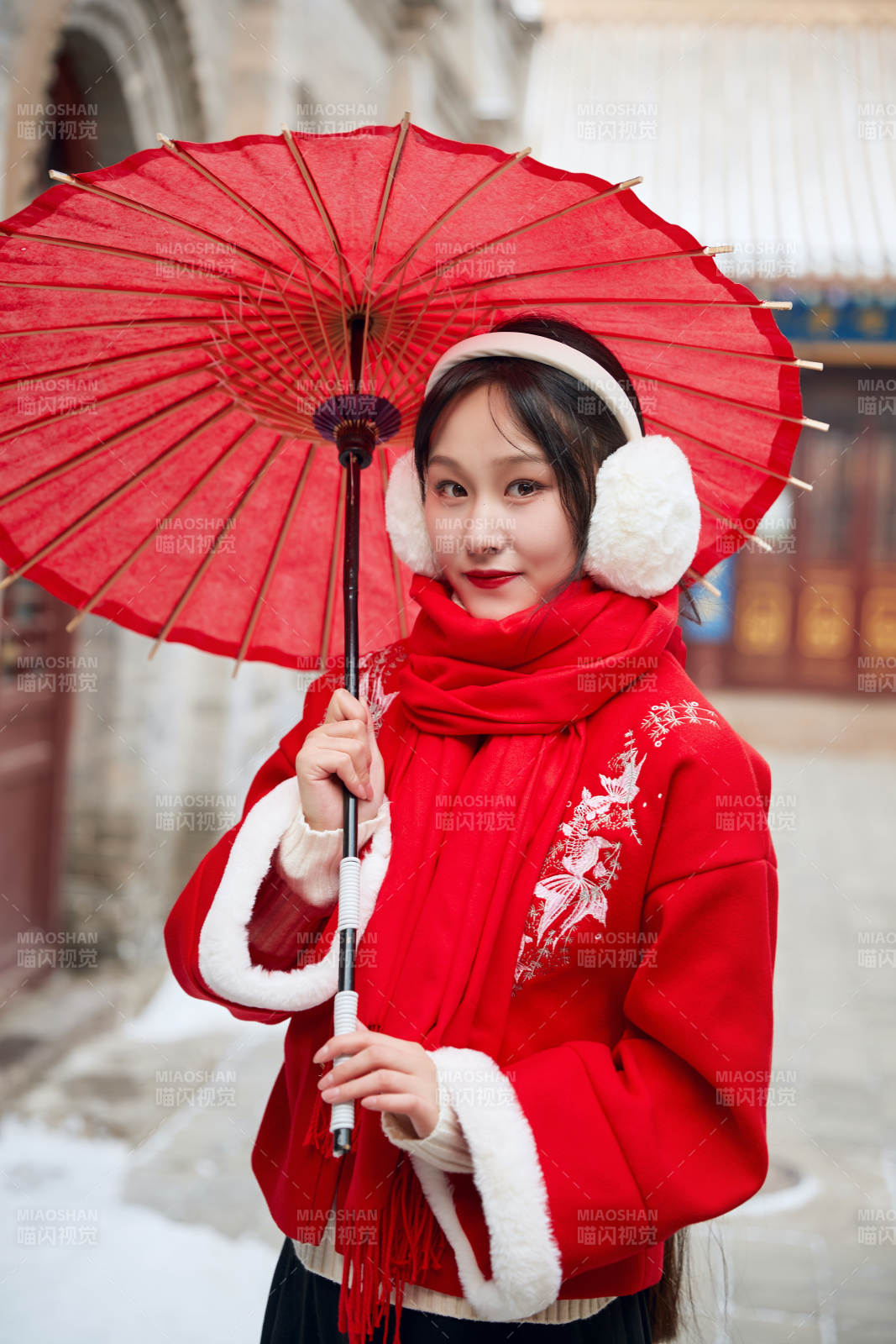 雪后在老城古巷穿著喜慶服飾的亞洲少女