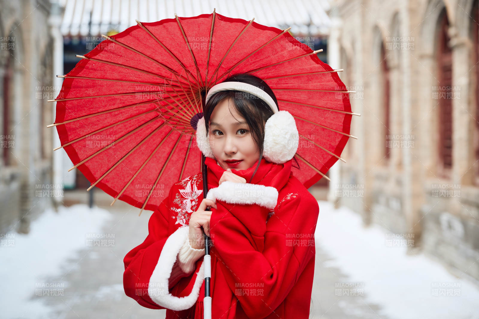 雪后在老城古巷穿著喜慶服飾的亞洲少女