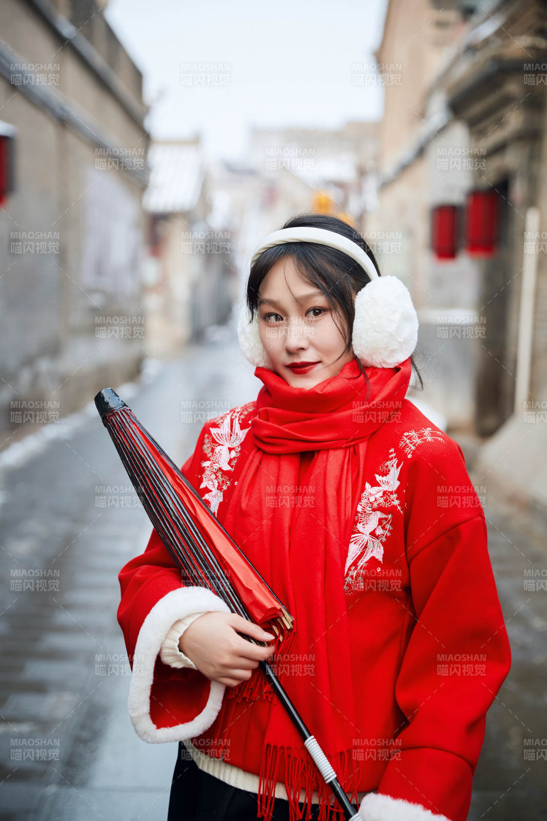 雪后在老城古巷穿著喜慶服飾的亞洲少女