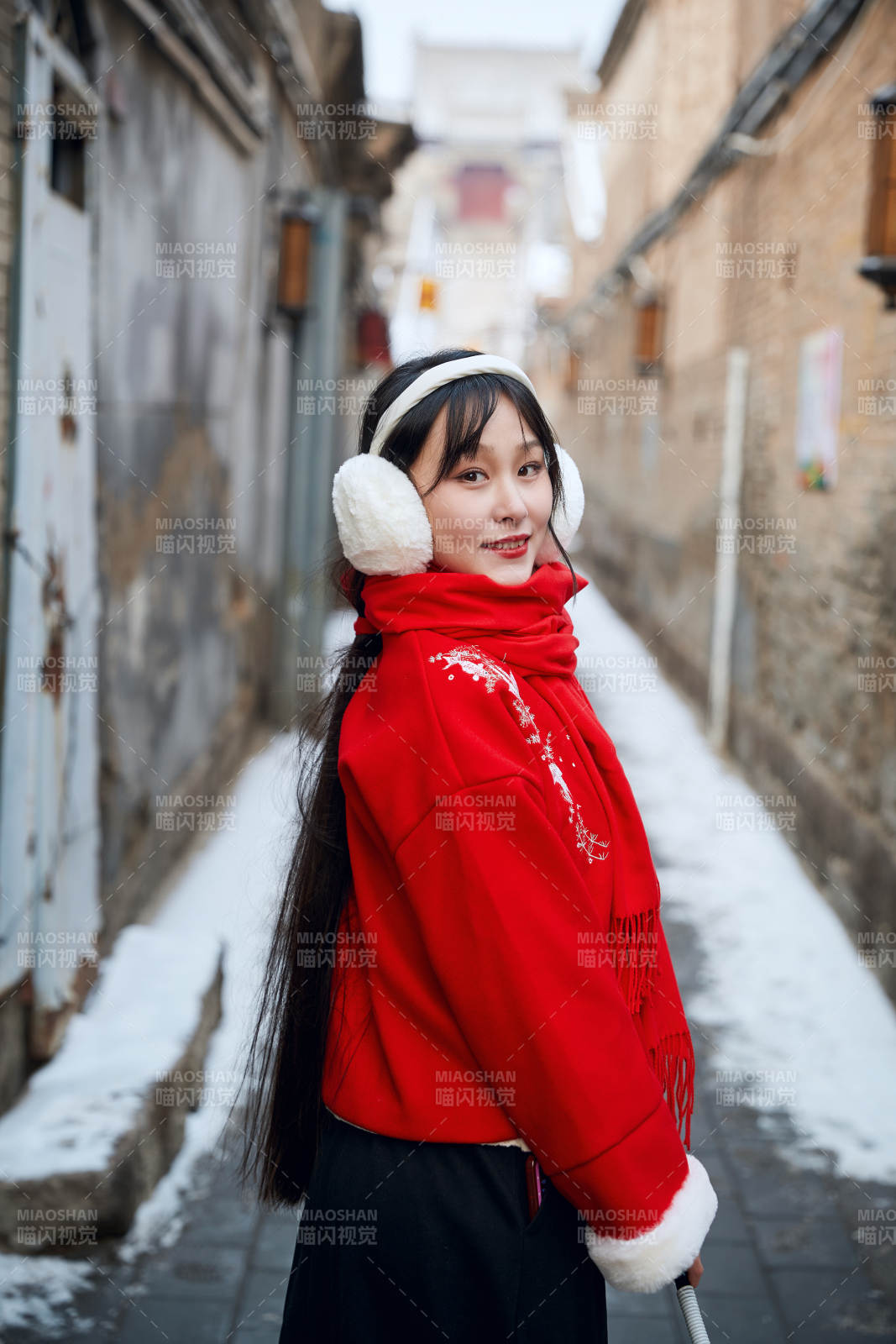 雪后在老城古巷穿著喜慶服飾的亞洲少女