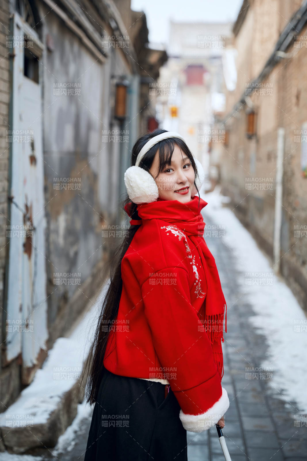 雪后在老城古巷穿著喜慶服飾的亞洲少女
