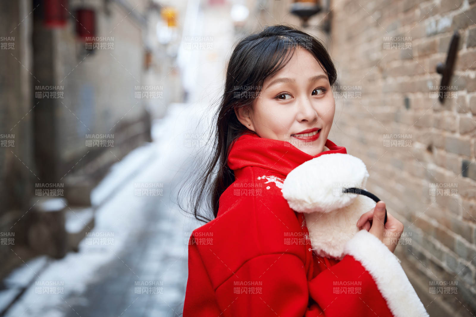 雪后在老城古巷穿著喜慶服飾的亞洲少女