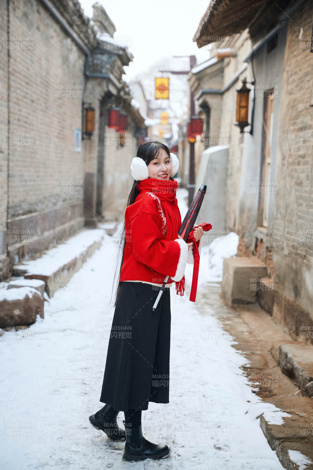 雪后在老城古巷穿著喜慶服飾的亞洲少女