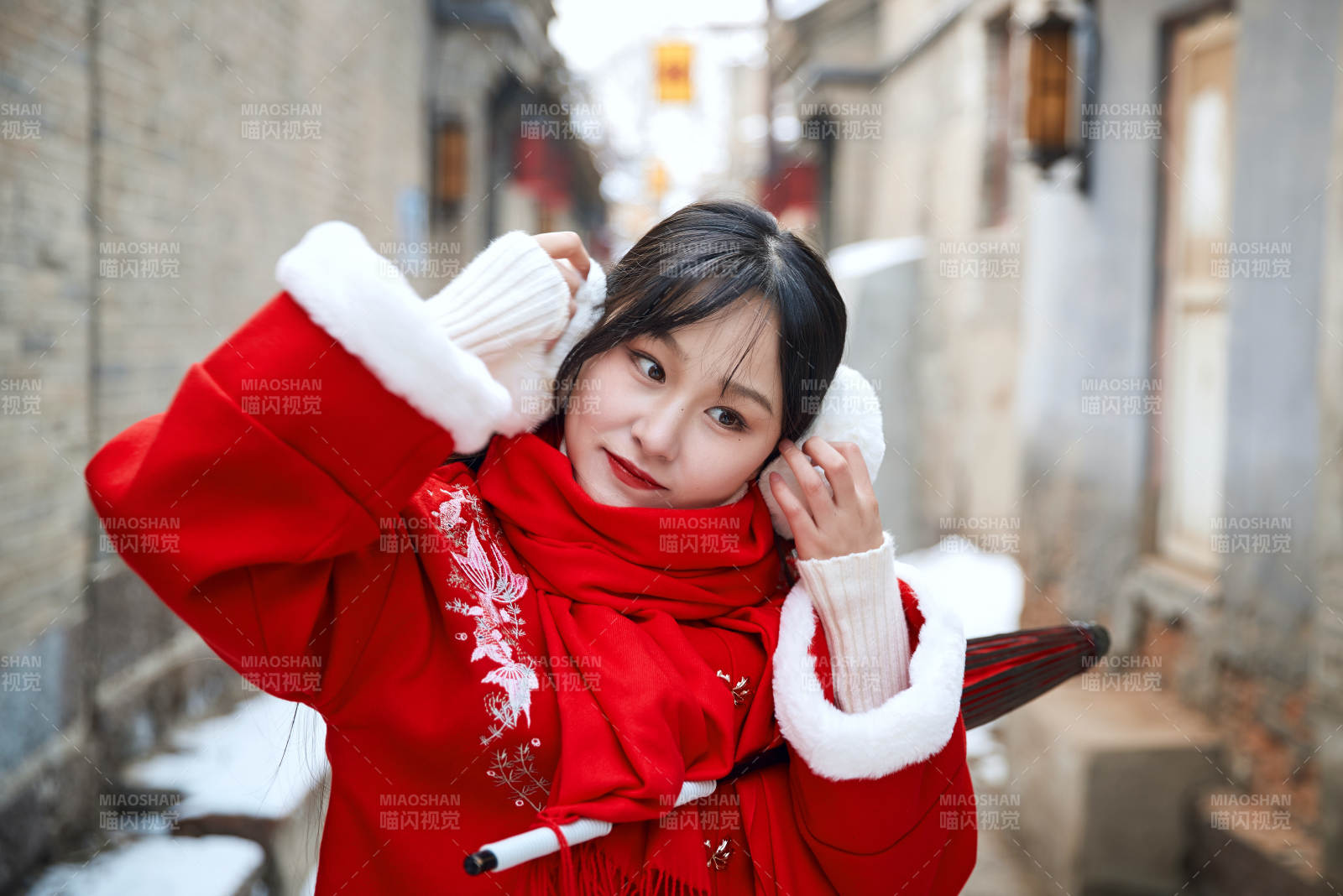 雪后在老城古巷穿著喜慶服飾的亞洲少女