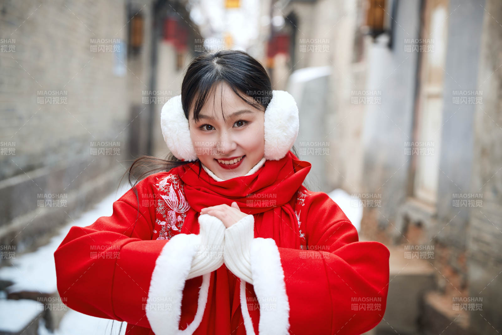 雪后在老城古巷穿著喜慶服飾的亞洲少女
