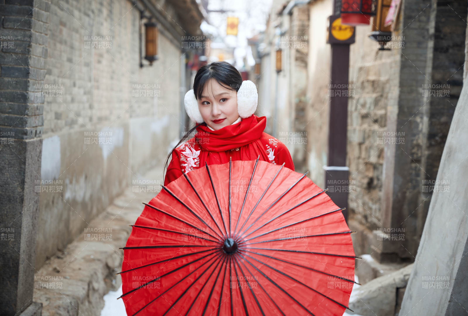 雪后在老城古巷穿著喜慶服飾的亞洲少女