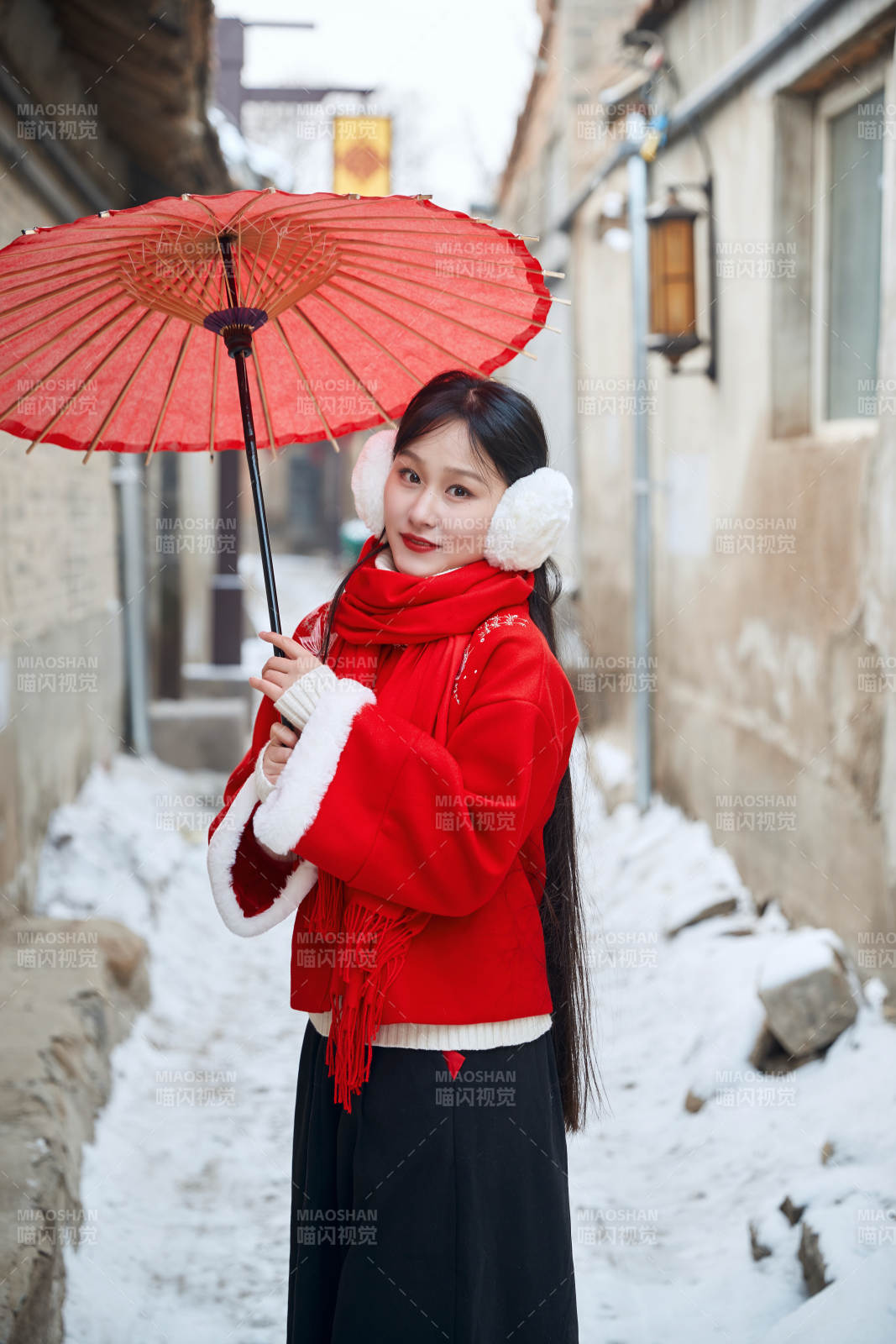 雪后在老城古巷穿著喜慶服飾的亞洲少女