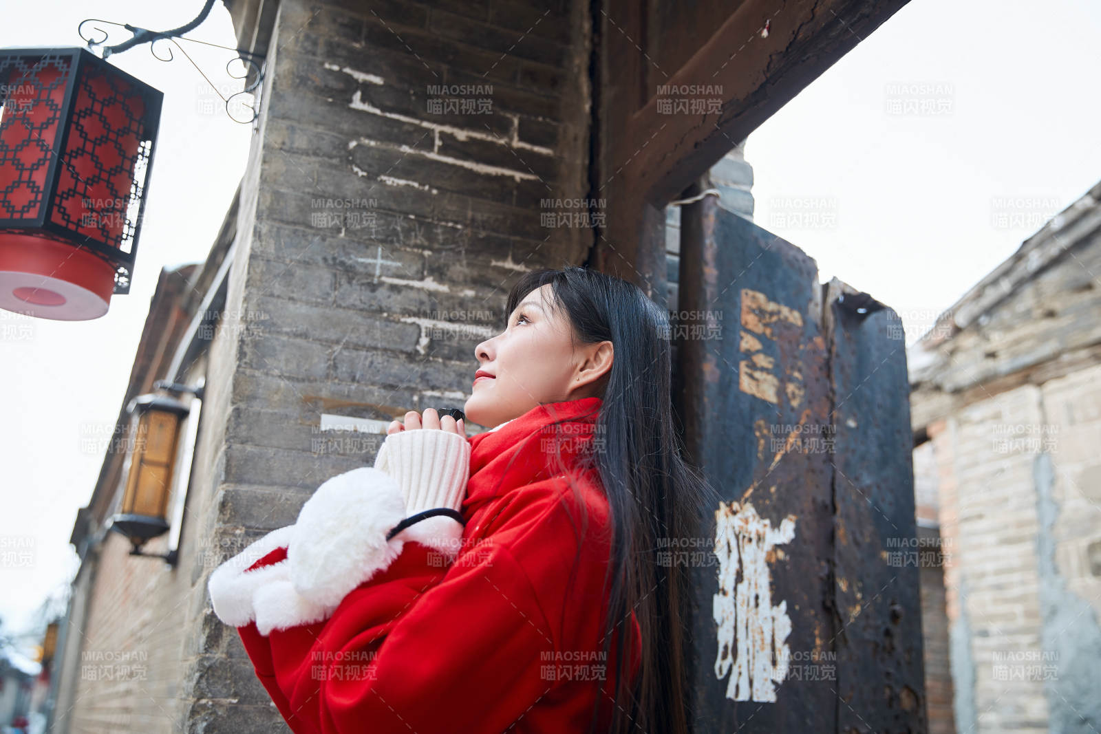 雪后在老城古巷穿著喜慶服飾的亞洲少女