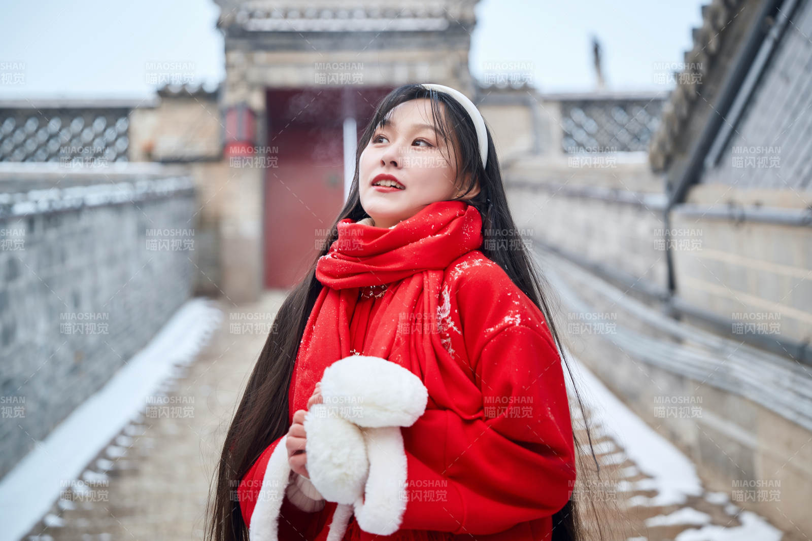 雪后在老城古巷穿著喜慶服飾的亞洲少女