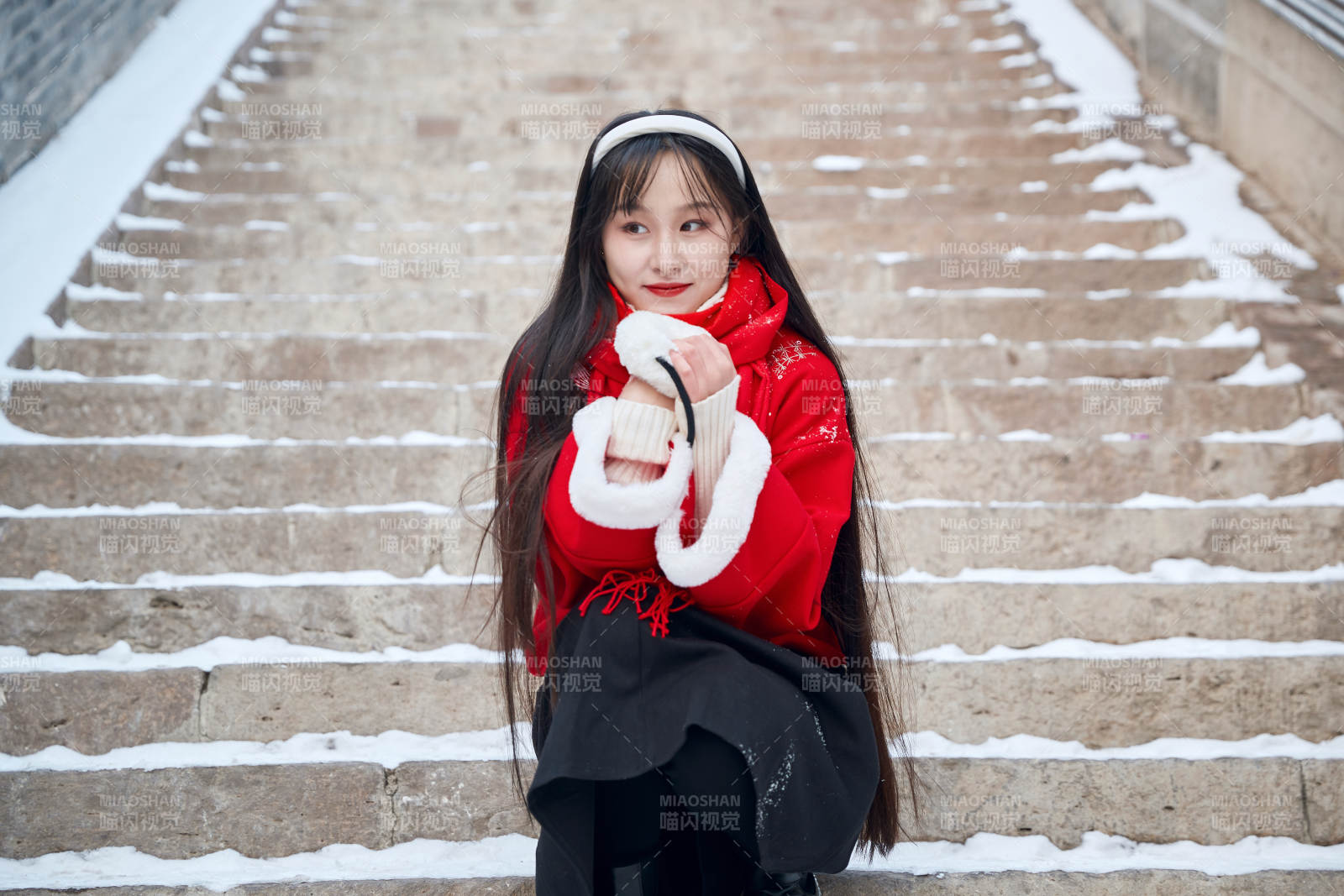 雪后在老城古巷穿着喜庆服饰的亚洲少女