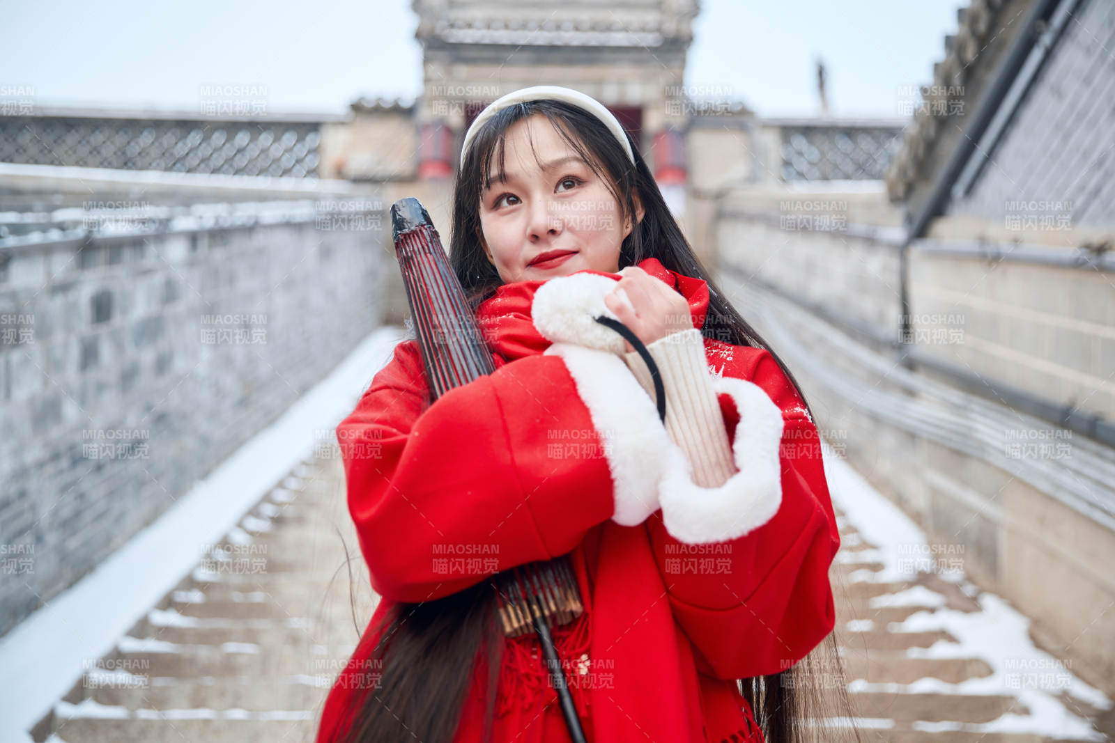 雪后在老城古巷穿著喜慶服飾的亞洲少女