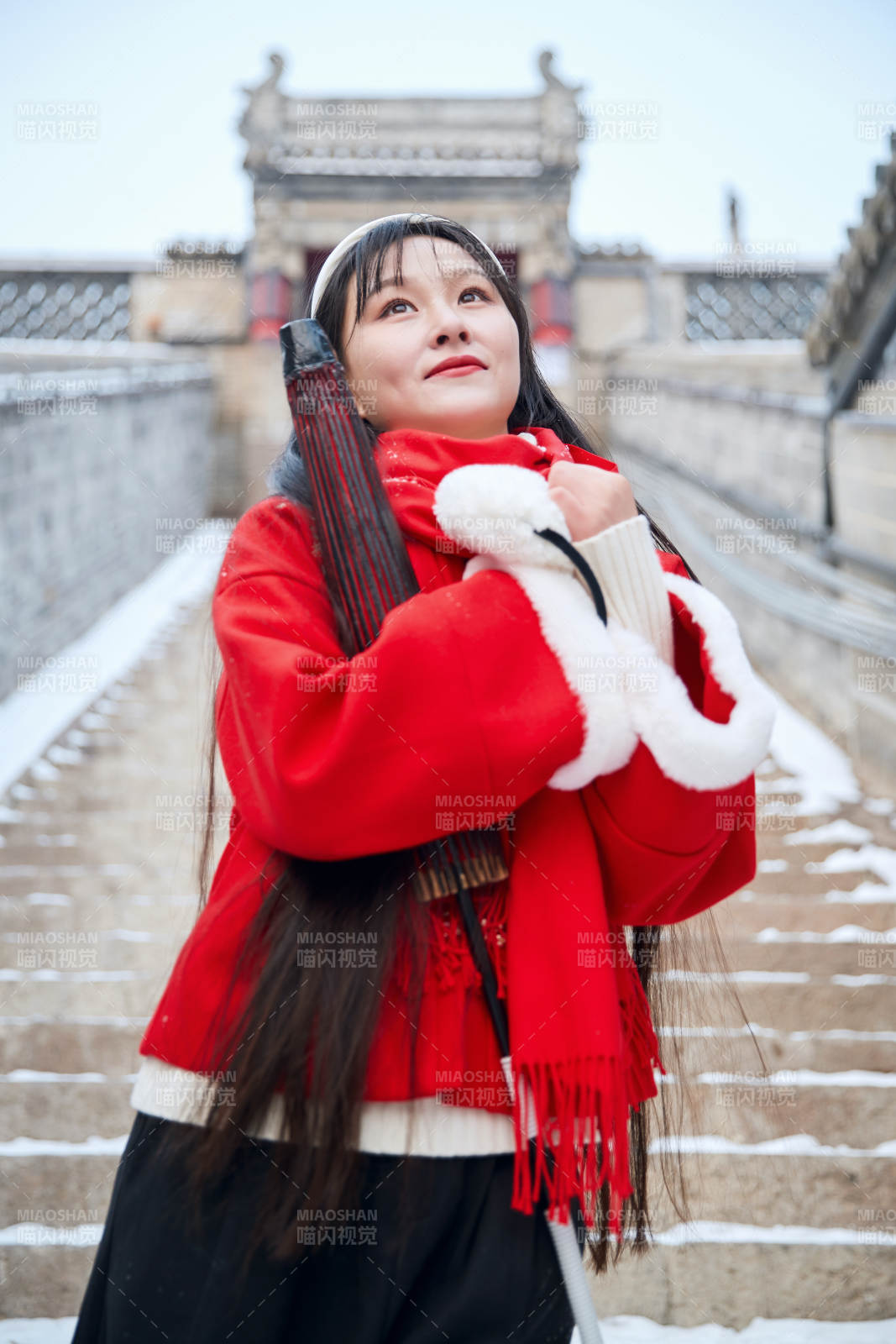 雪后在老城古巷穿著喜慶服飾的亞洲少女