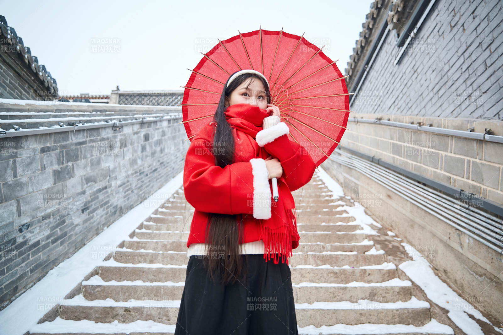雪后在老城古巷穿著喜慶服飾的亞洲少女