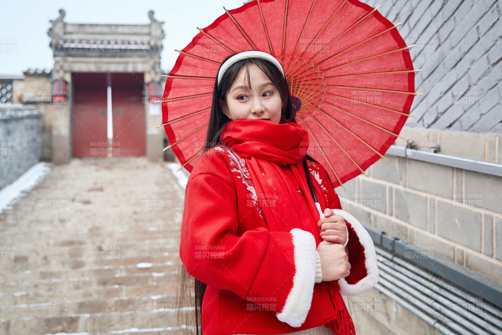 雪后在老城古巷穿著喜慶服飾的亞洲少女