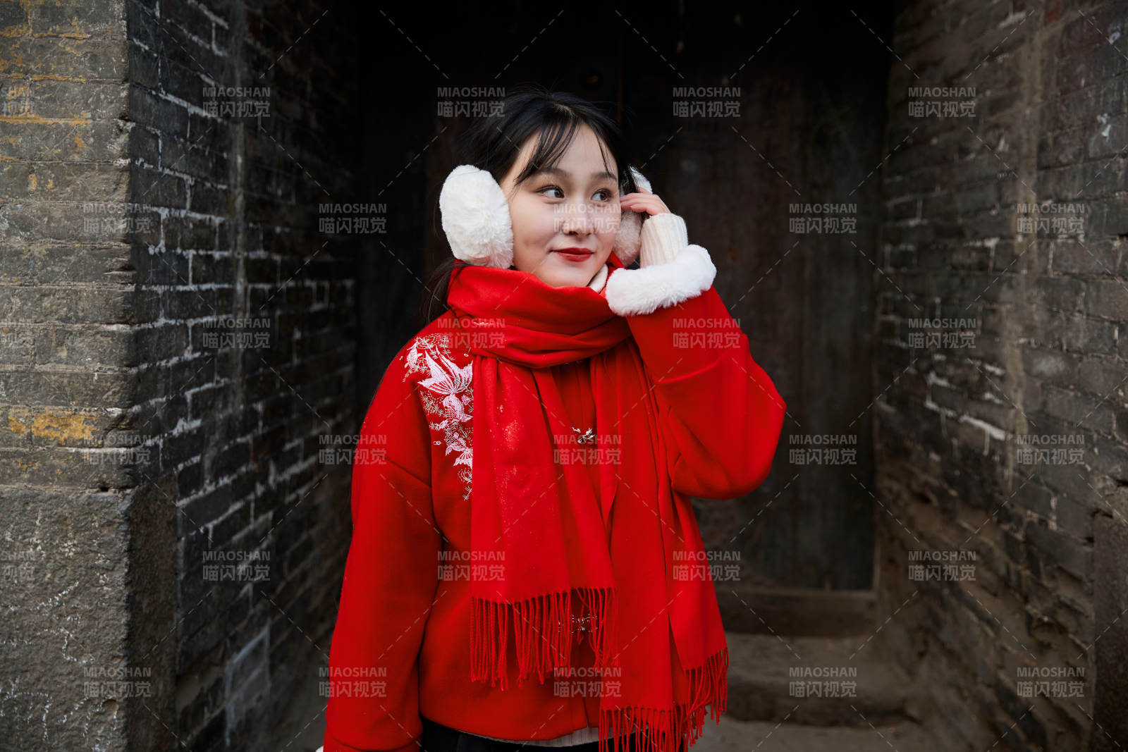 雪后在老城古巷穿著喜慶服飾的亞洲少女