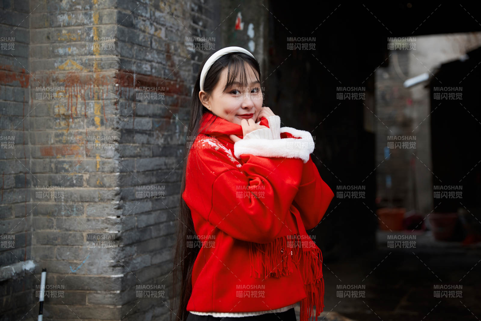 雪后在老城古巷穿著喜慶服飾的亞洲少女