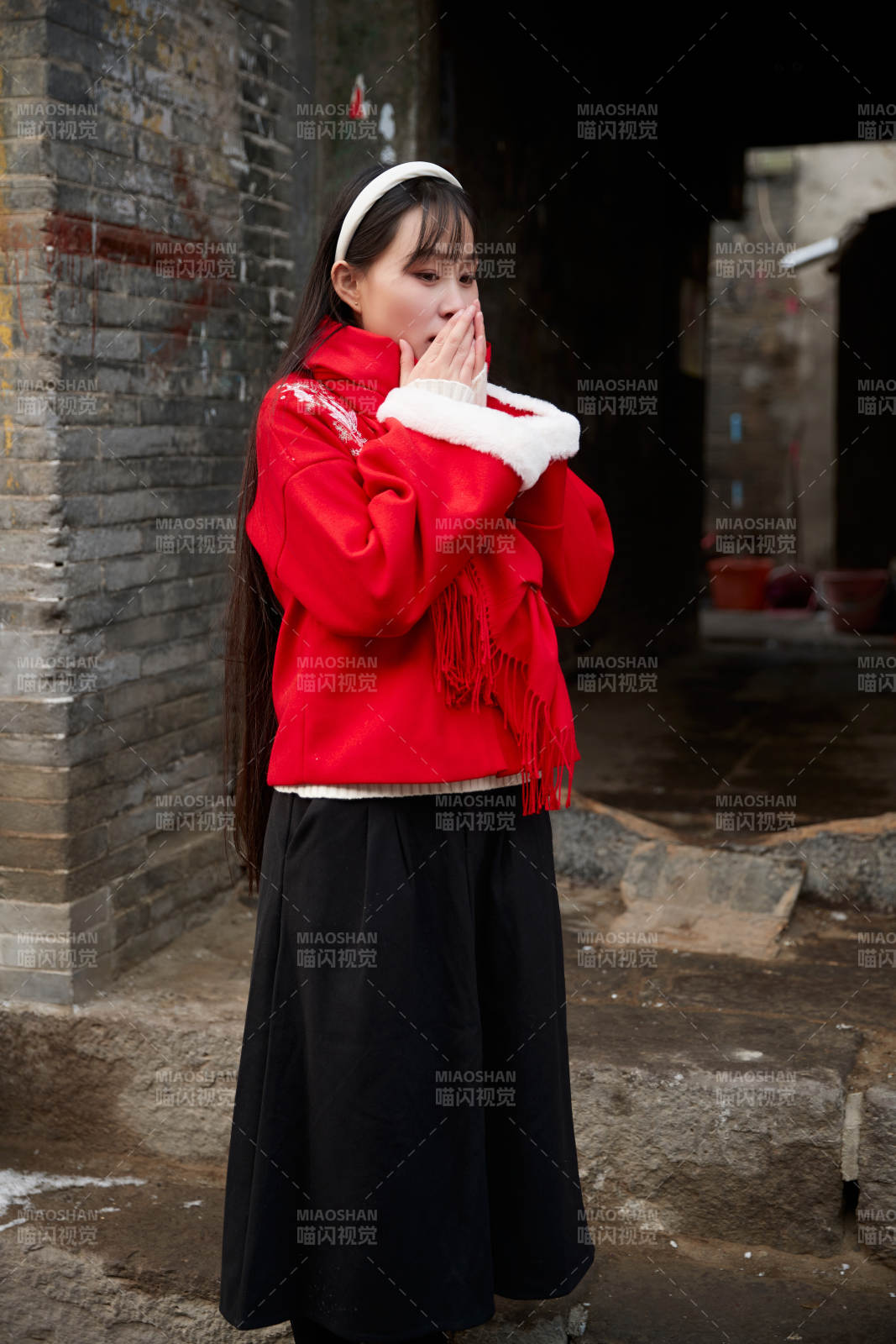 雪后在老城古巷穿著喜慶服飾的亞洲少女