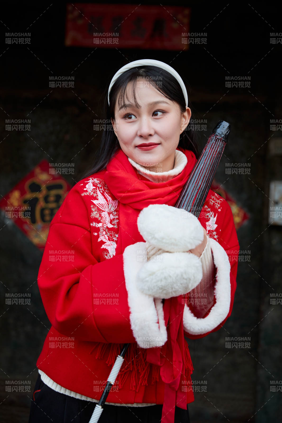 雪后在老城古巷穿著喜慶服飾的亞洲少女