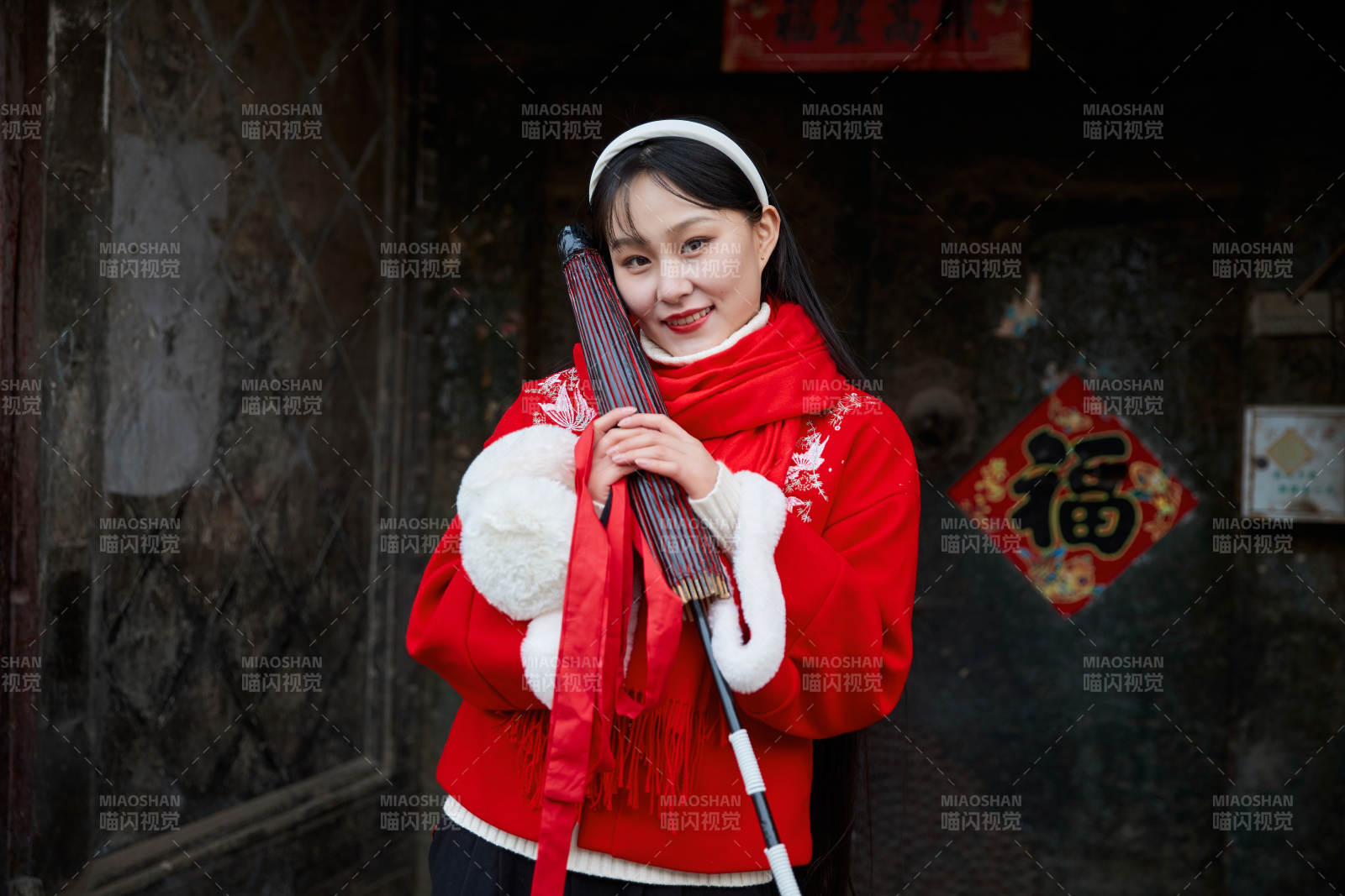 雪后在老城古巷穿着喜庆服饰的亚洲少女