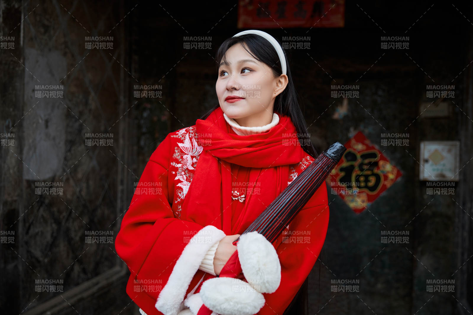 雪后在老城古巷穿着喜庆服饰的亚洲少女