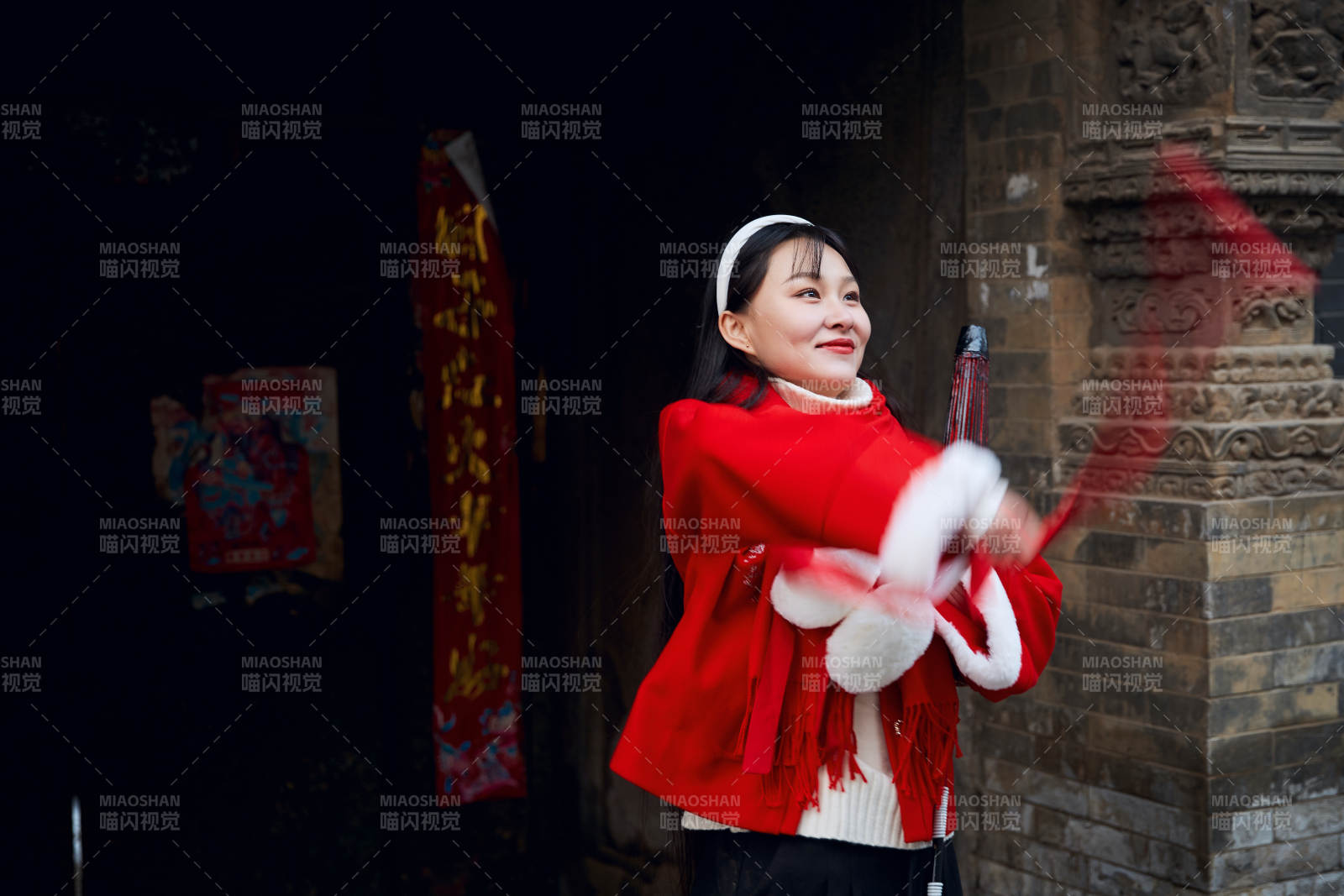 雪后在老城古巷穿着喜庆服饰的亚洲少女