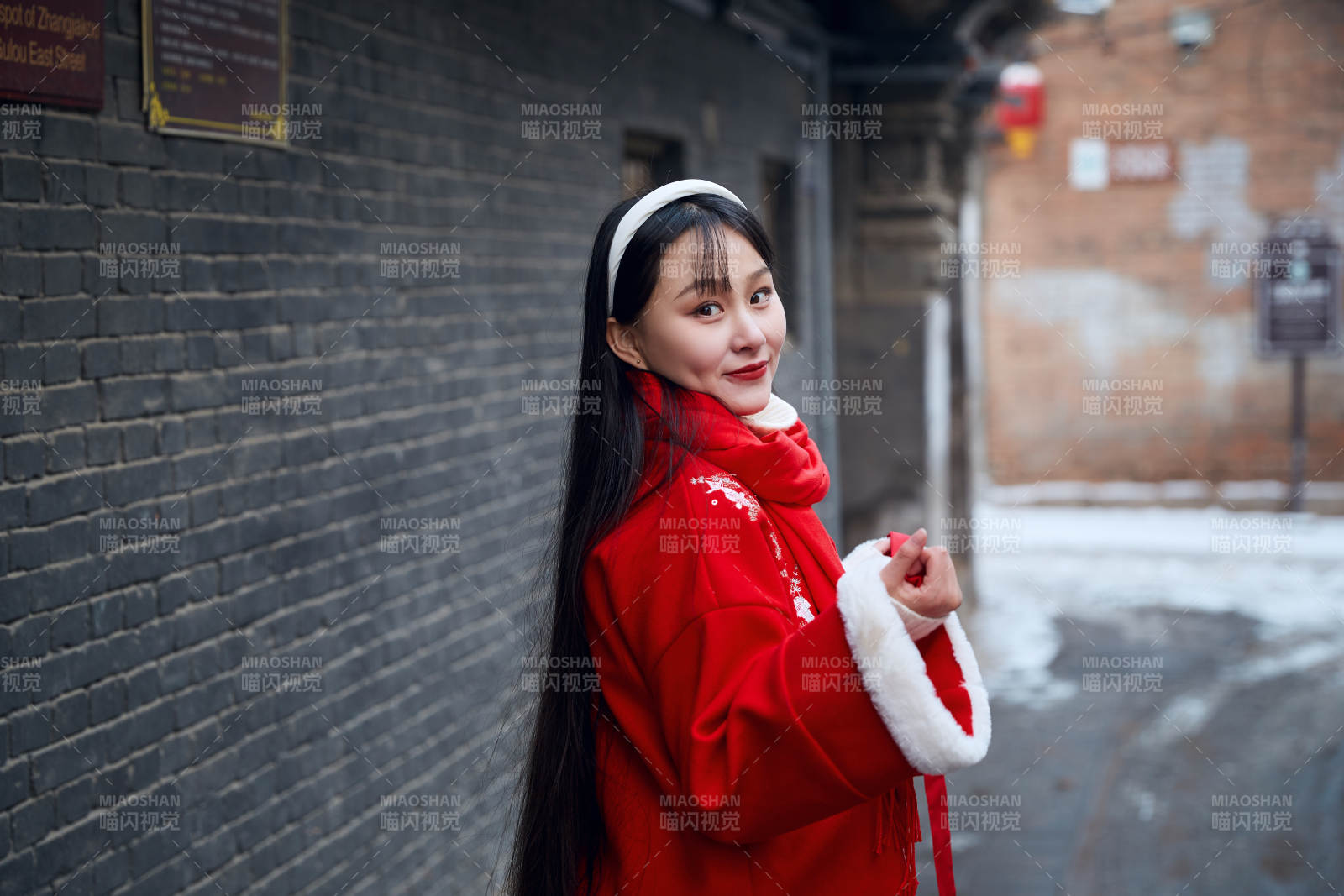 雪后在老城古巷穿著喜慶服飾的亞洲少女