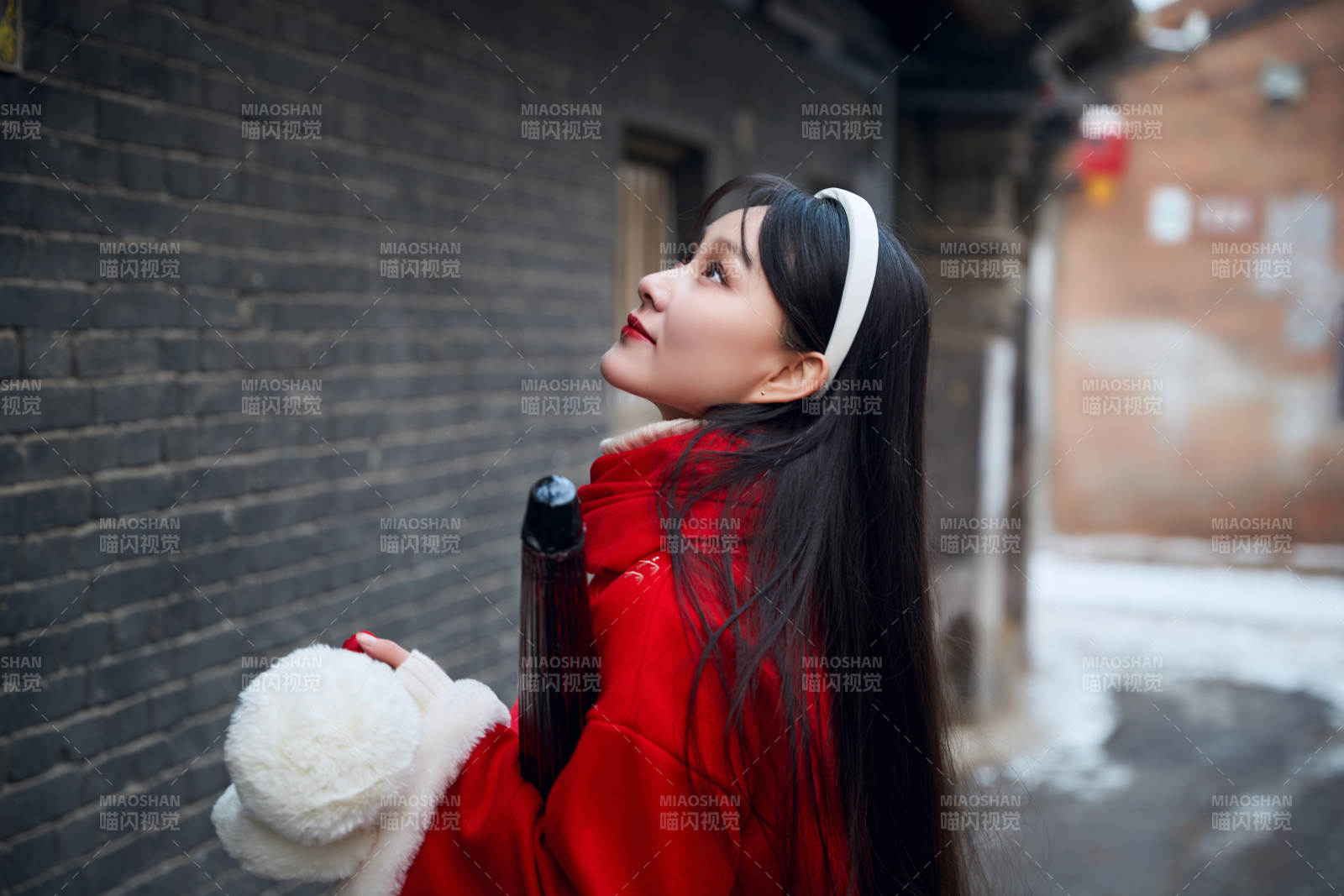 雪后在老城古巷穿著喜慶服飾的亞洲少女