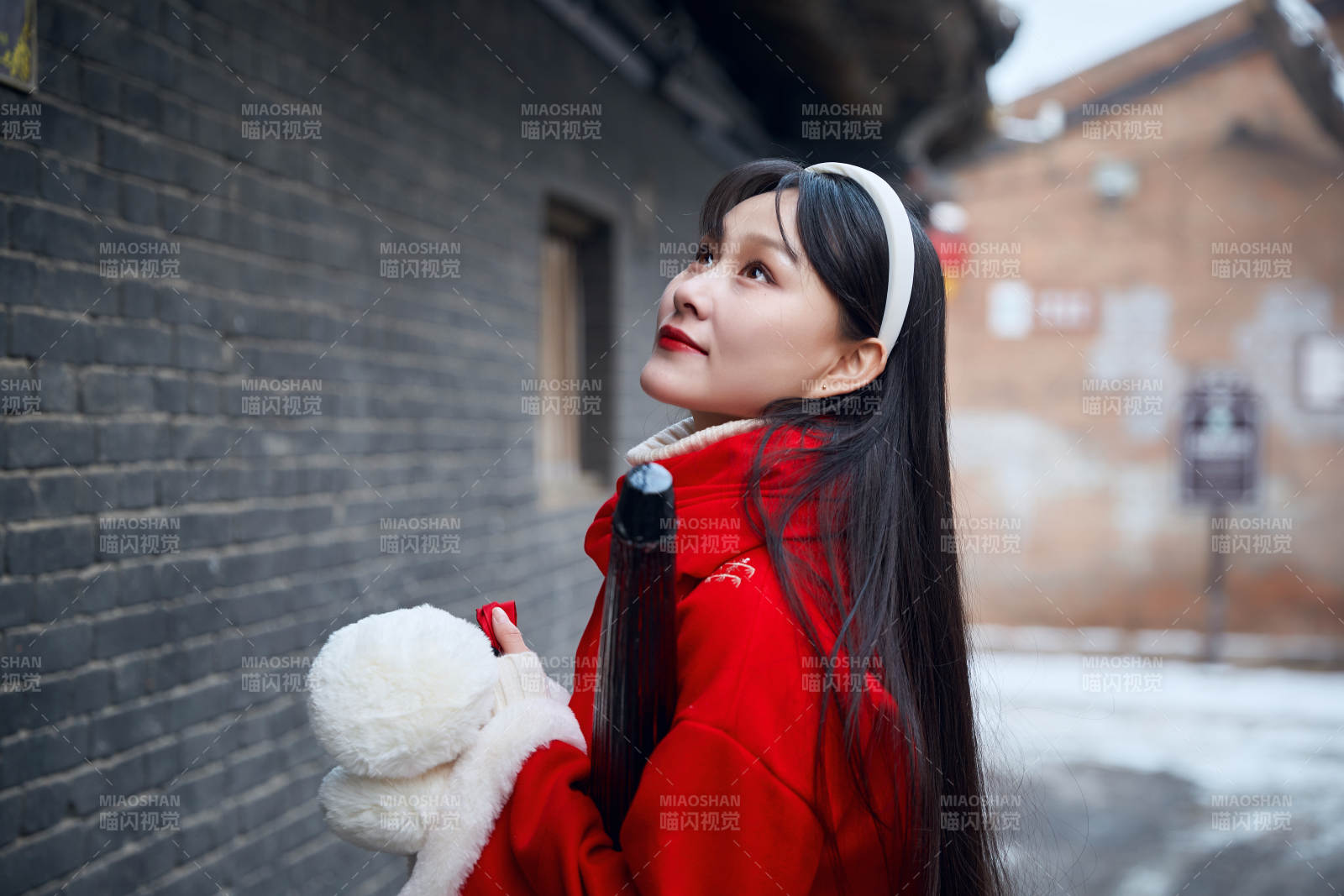 雪后在老城古巷穿著喜慶服飾的亞洲少女