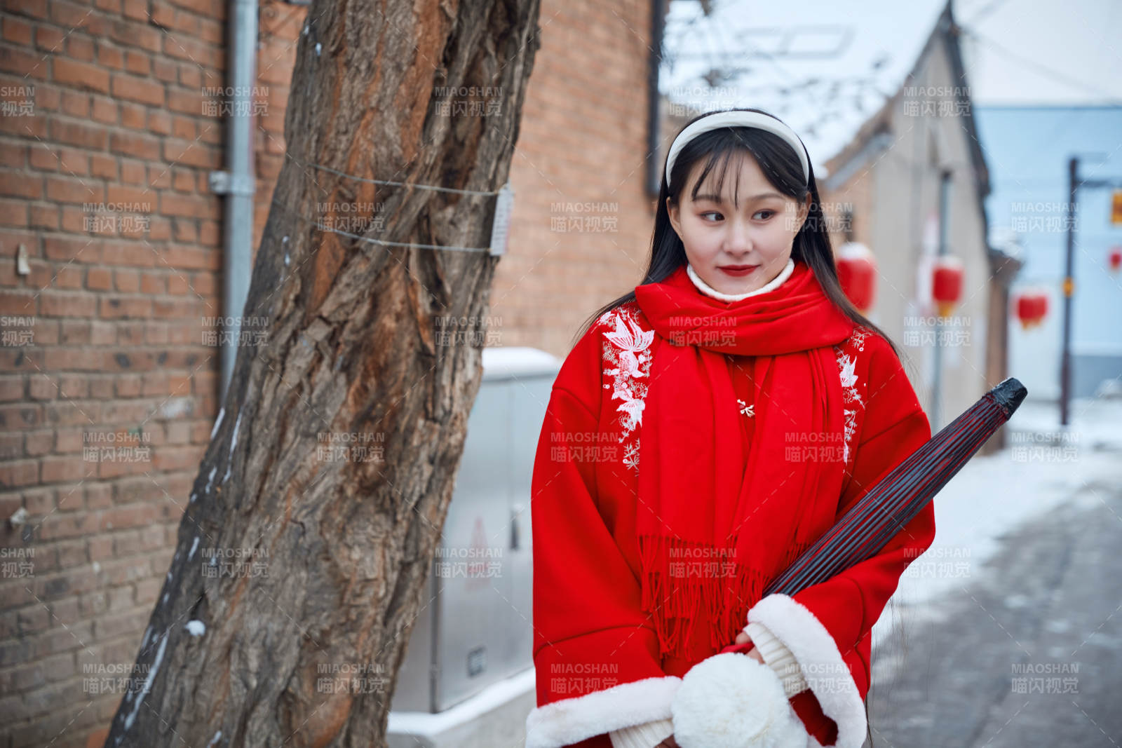 雪后在老城古巷穿着喜庆服饰的亚洲少女