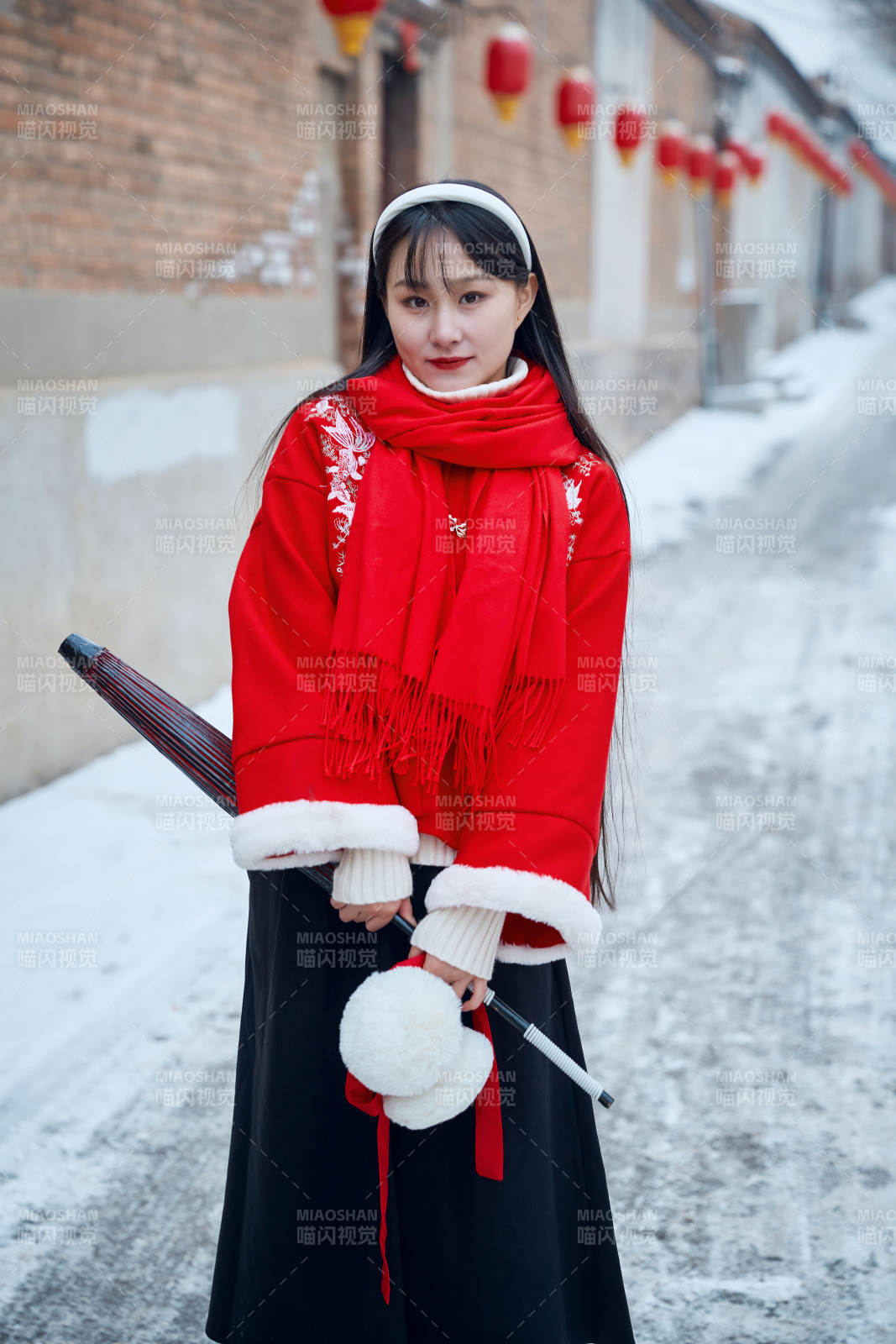 雪后在老城古巷穿著喜慶服飾的亞洲少女